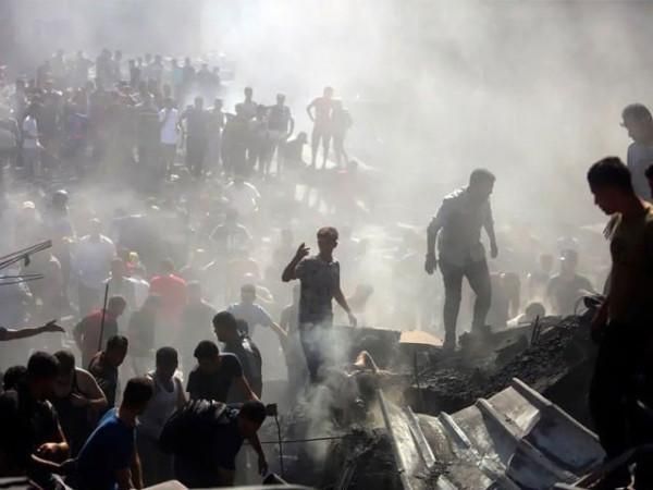 A large crowd of people moving through dense smoke and debris.