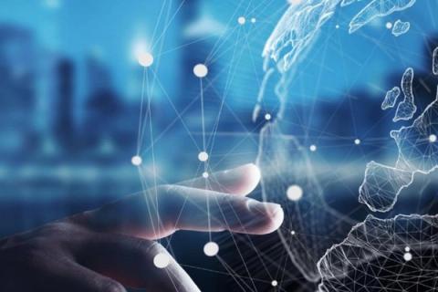 Hand interacting with a glowing digital global network and wireframe map.