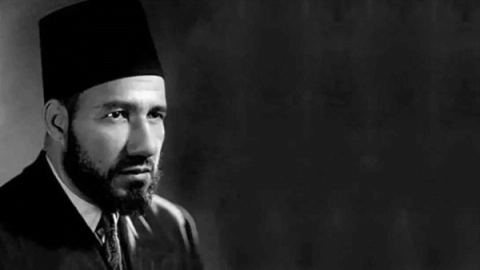 Black and white portrait of a man with a beard and a fez.