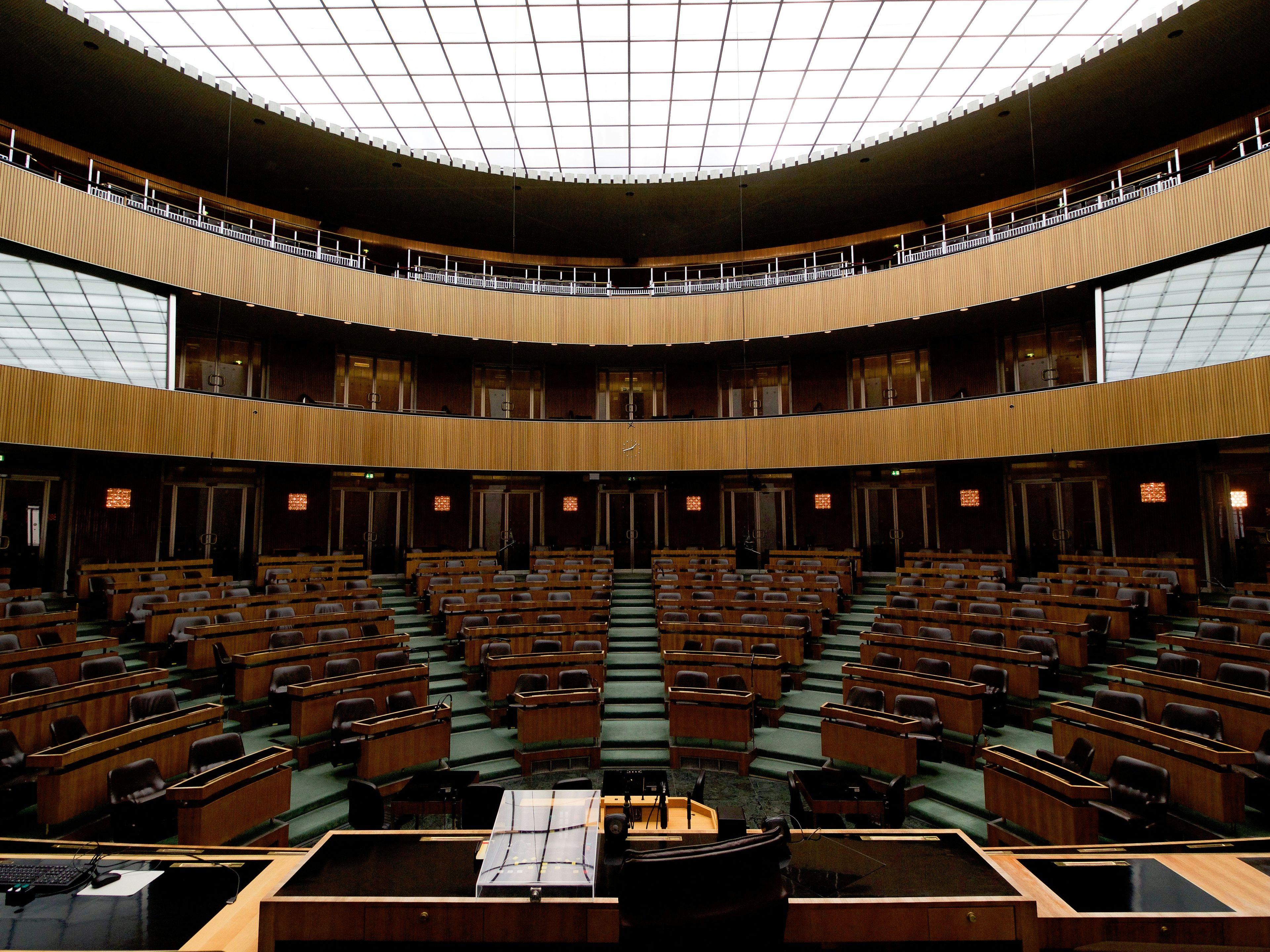 Circular sticker with "DEMOCRAZY demonstration of crazy" on a distressed blue wall.