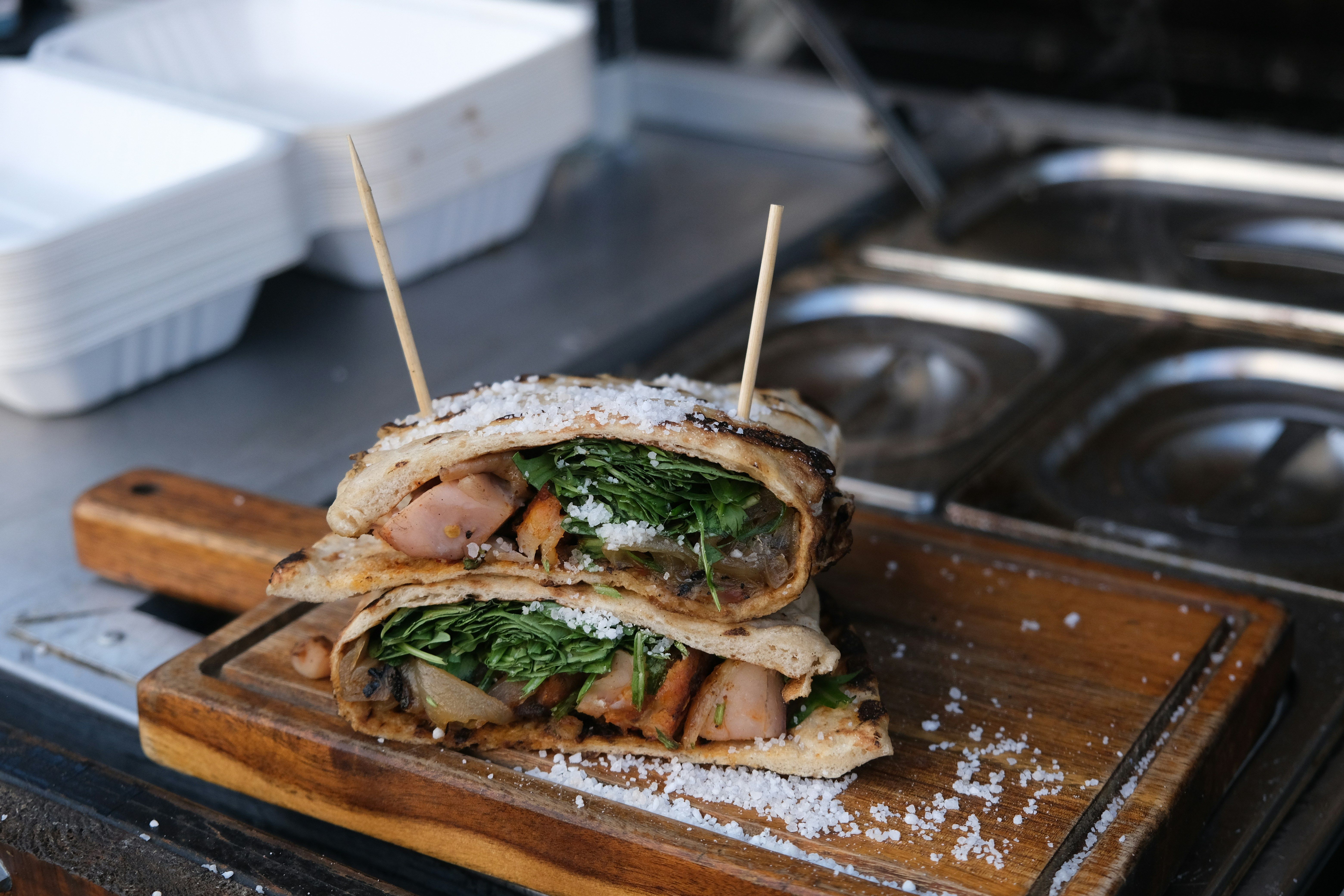 Burger with lettuce and tomato on brown wooden tray