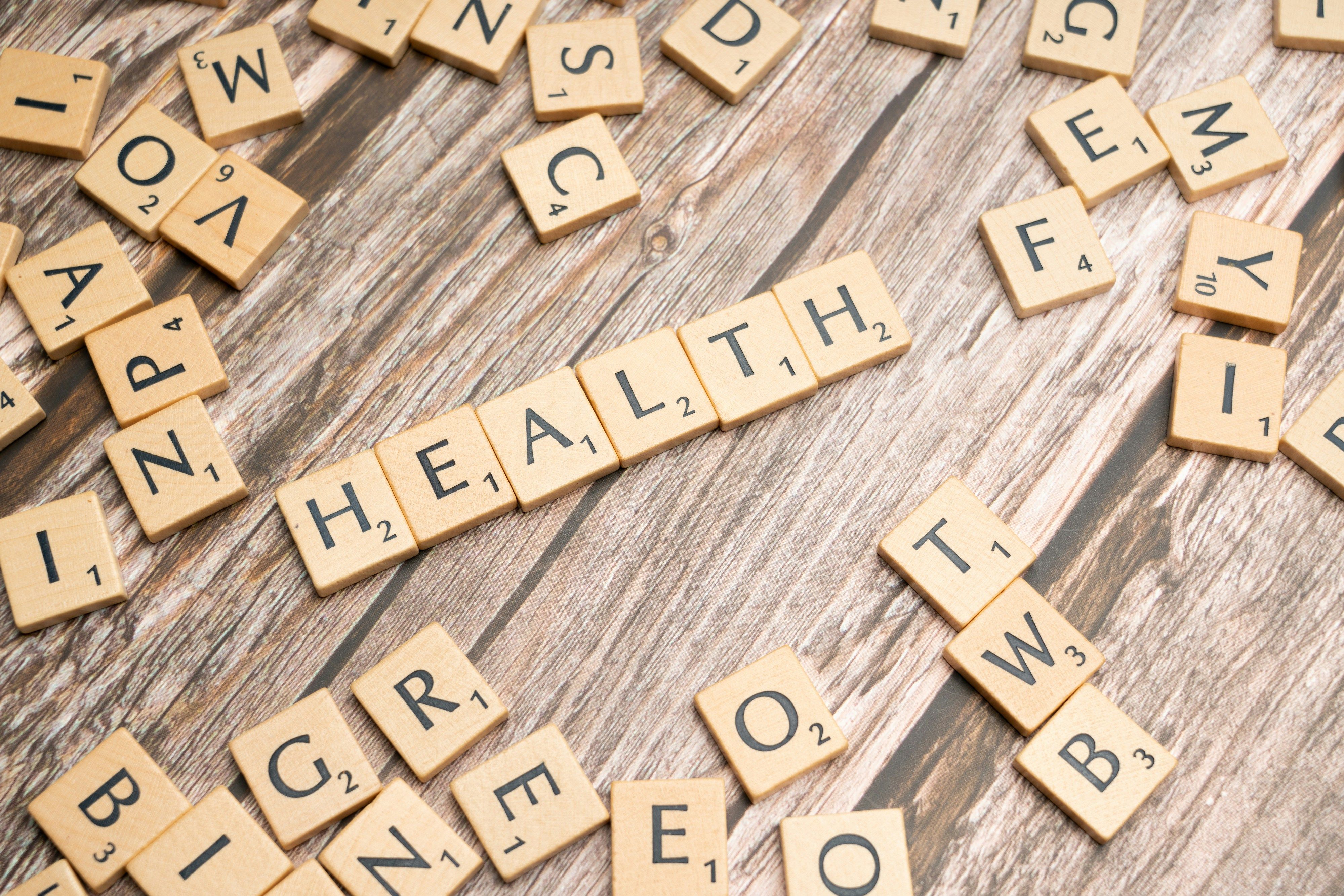 Scrabble tiles spelling the word health on a wooden surface