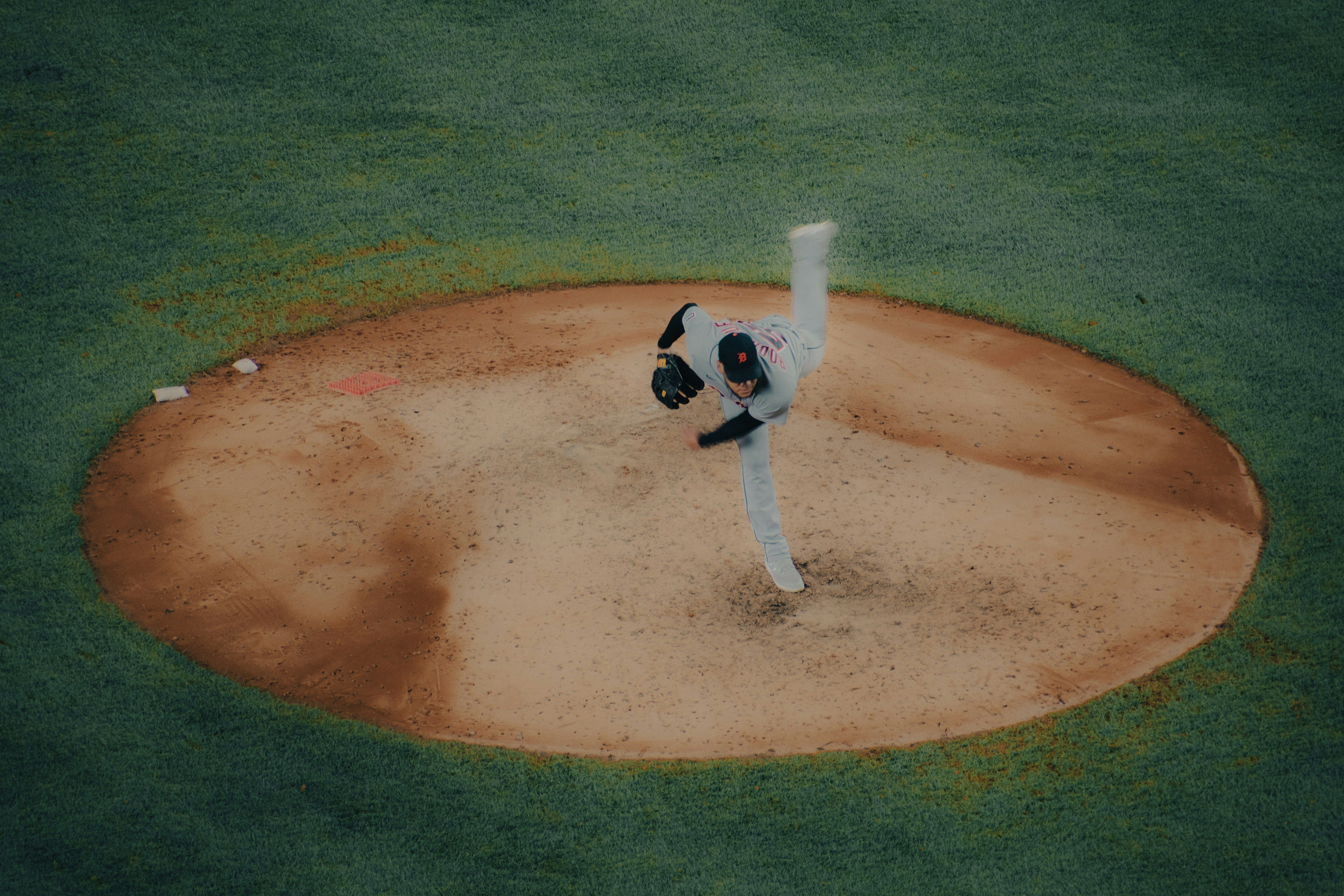 A baseball player pitching a ball on top of a field