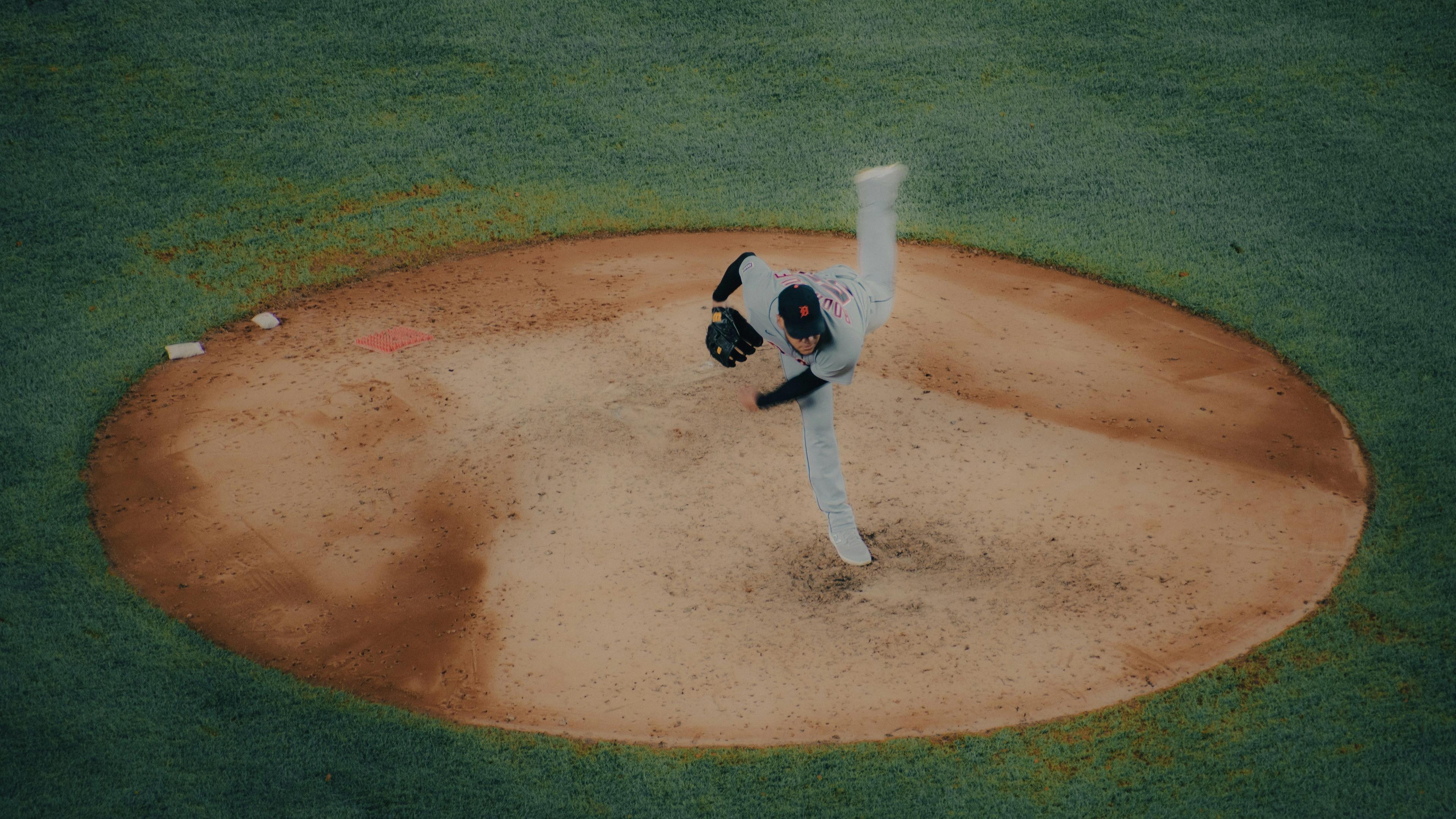 A baseball player pitching a ball on top of a field
