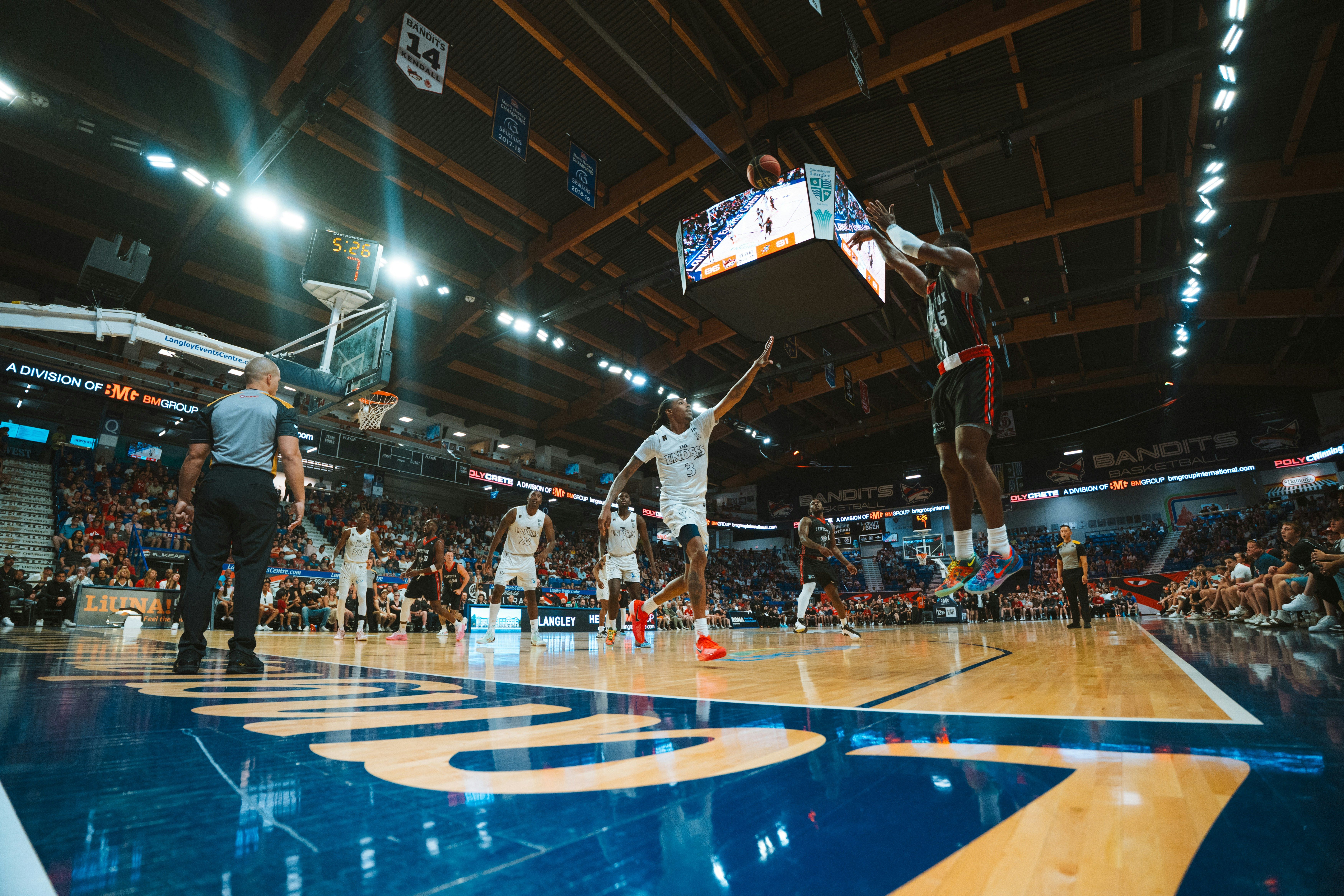 Basketball players compete in a game at a stadium