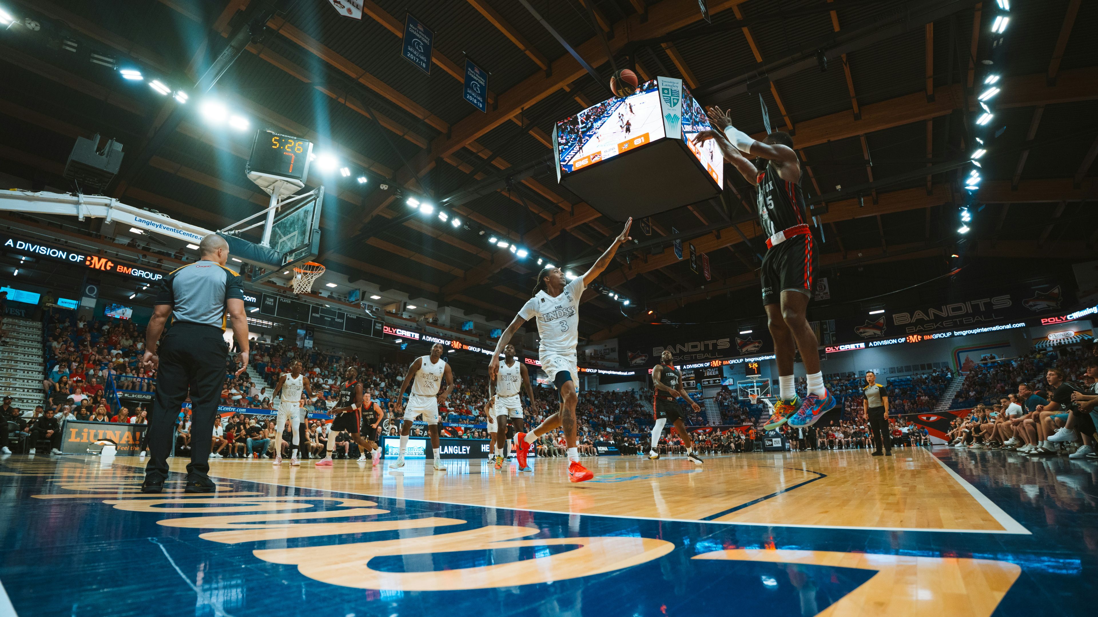 Basketball players compete in a game at a stadium