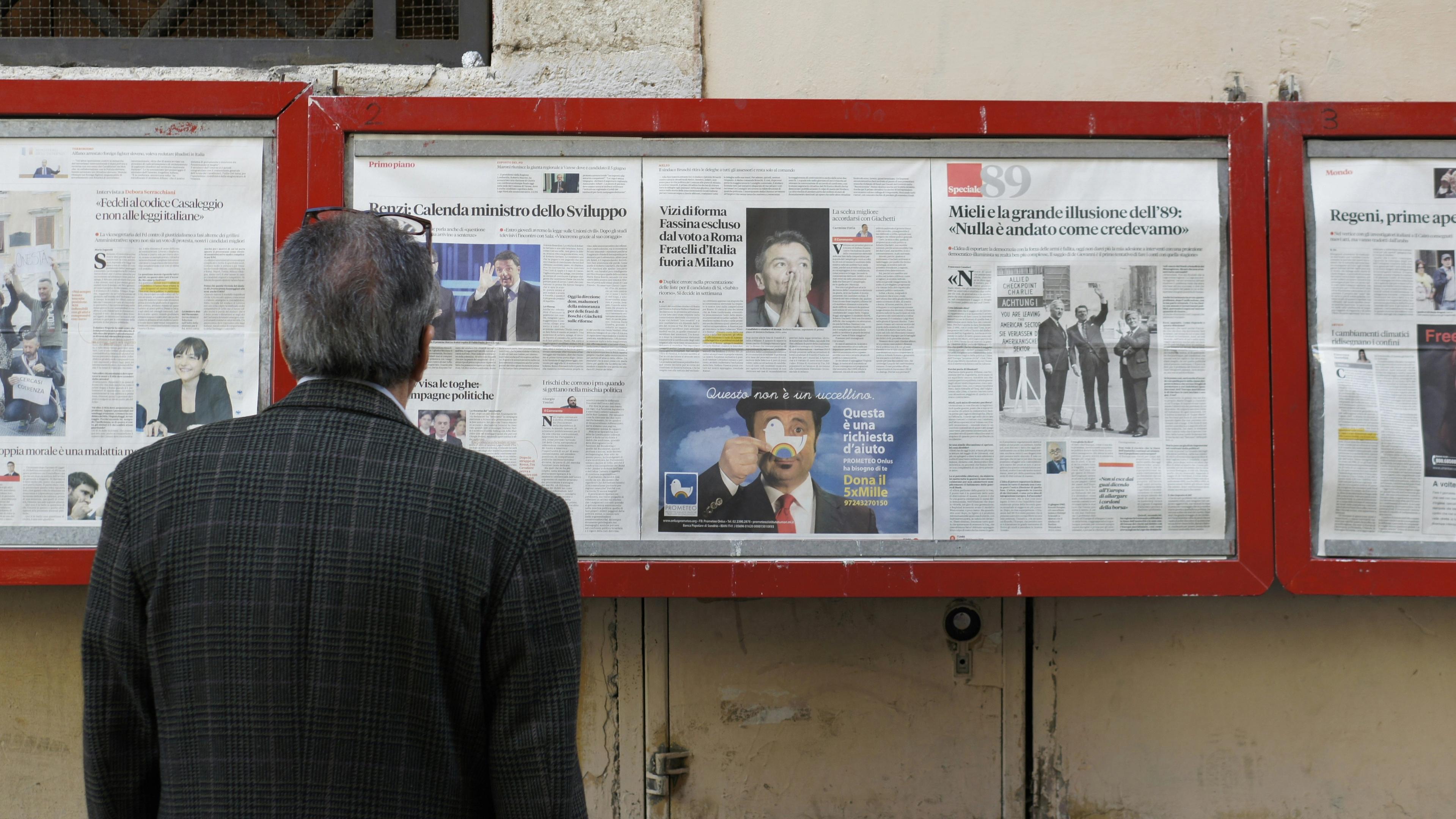 Man reading newspaper in bulletin board