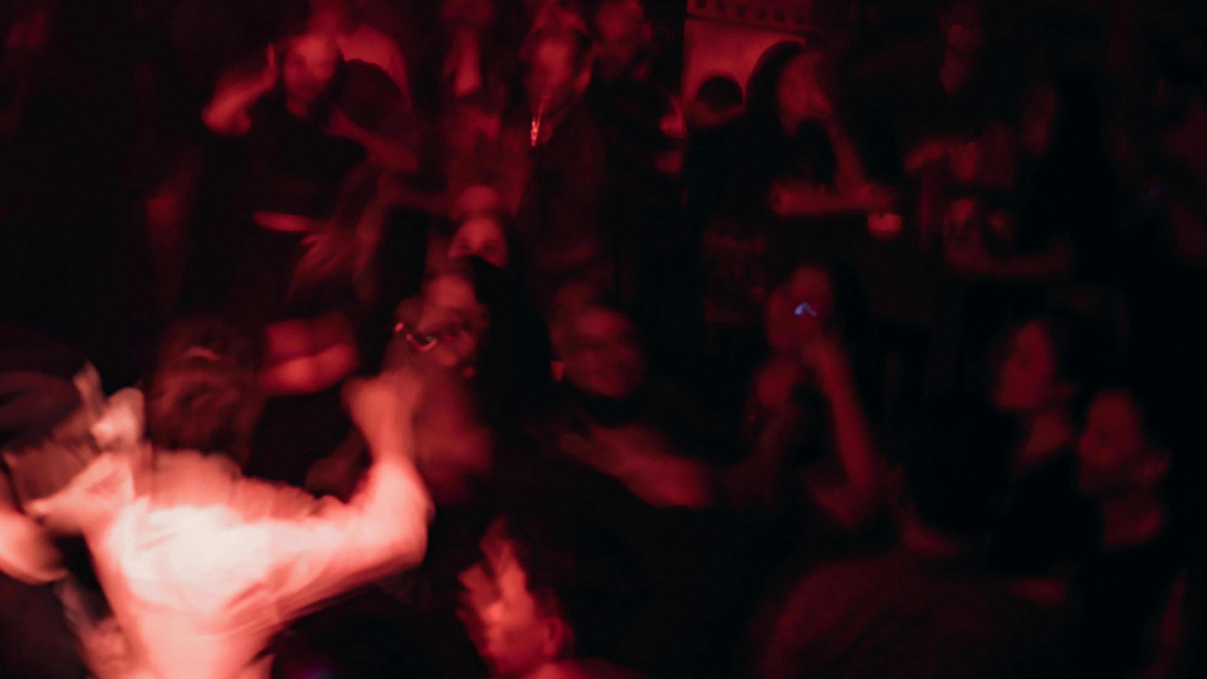 A blurry photo of a man dancing in a club