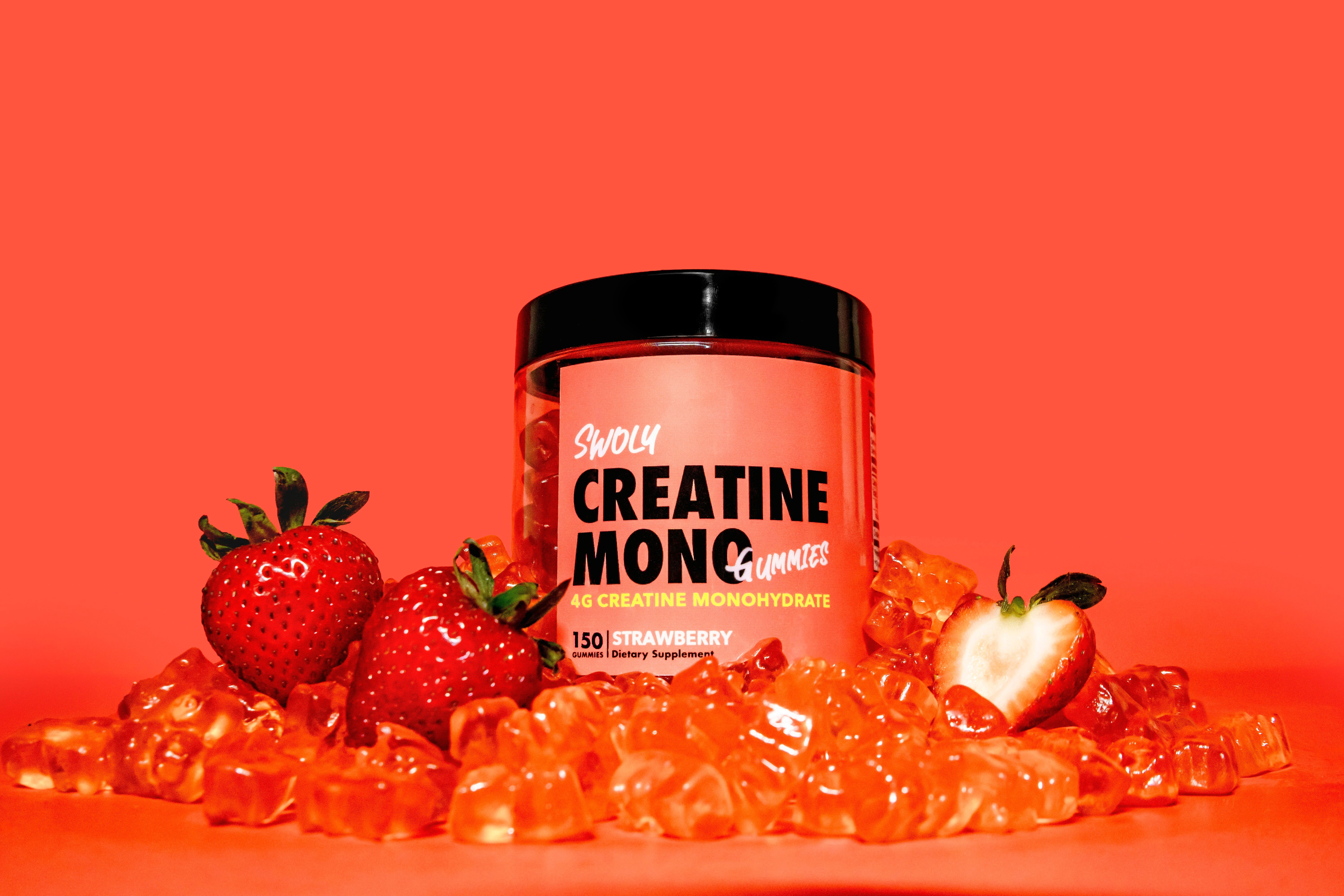 A jar of creatin monoc next to some strawberries