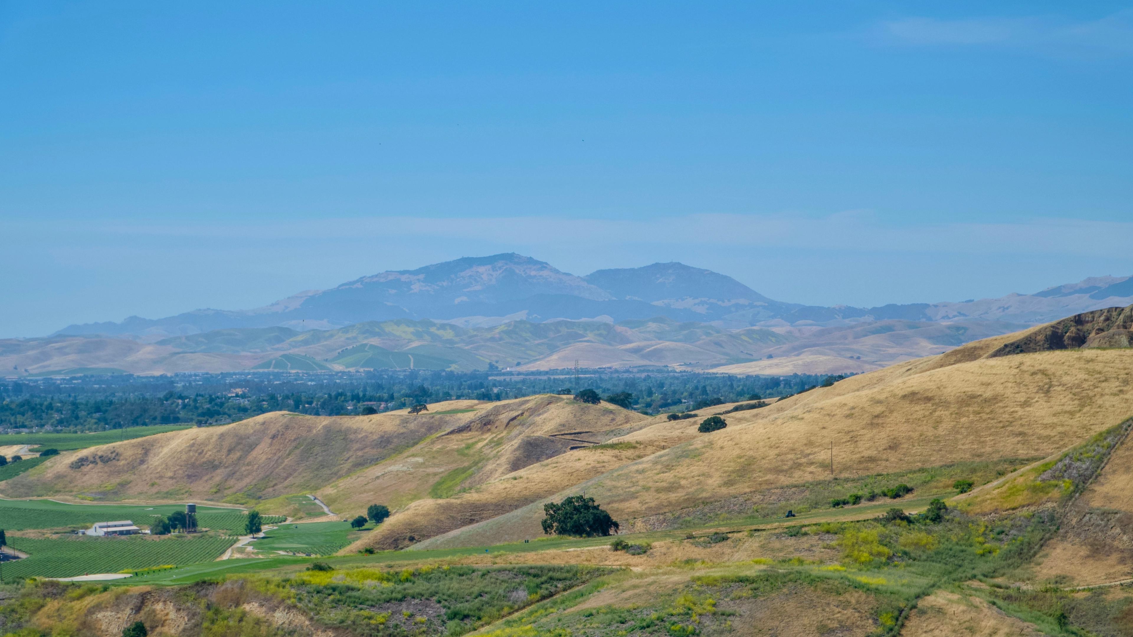 A scenic view of a valley with mountains in the background