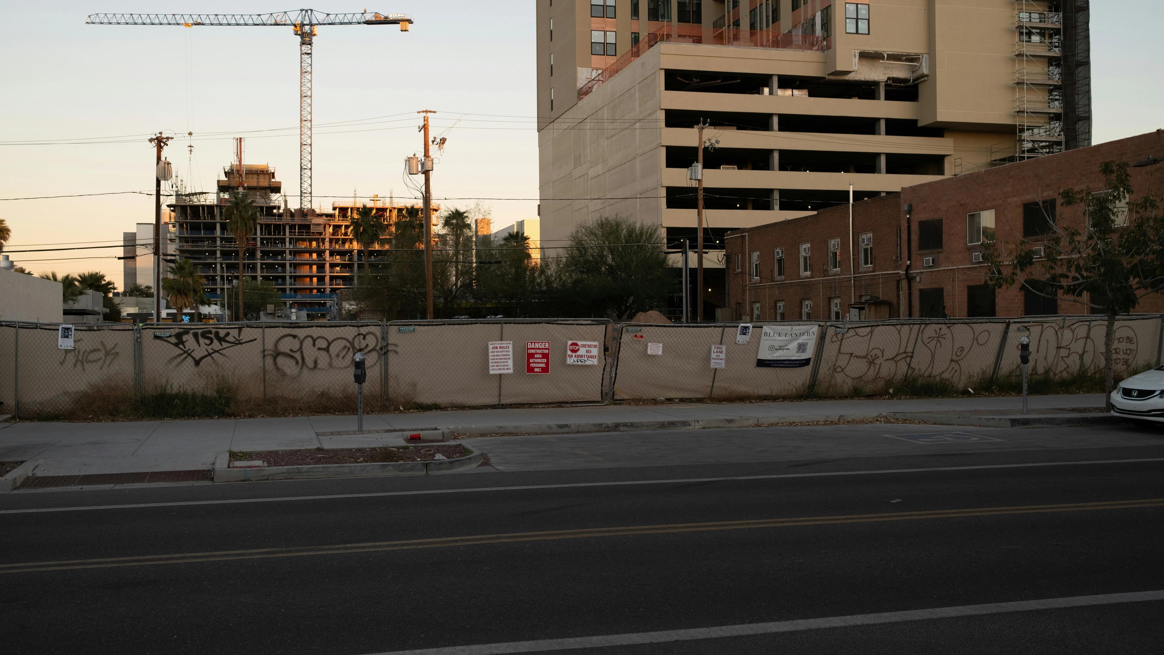 A city street with a construction site in the background