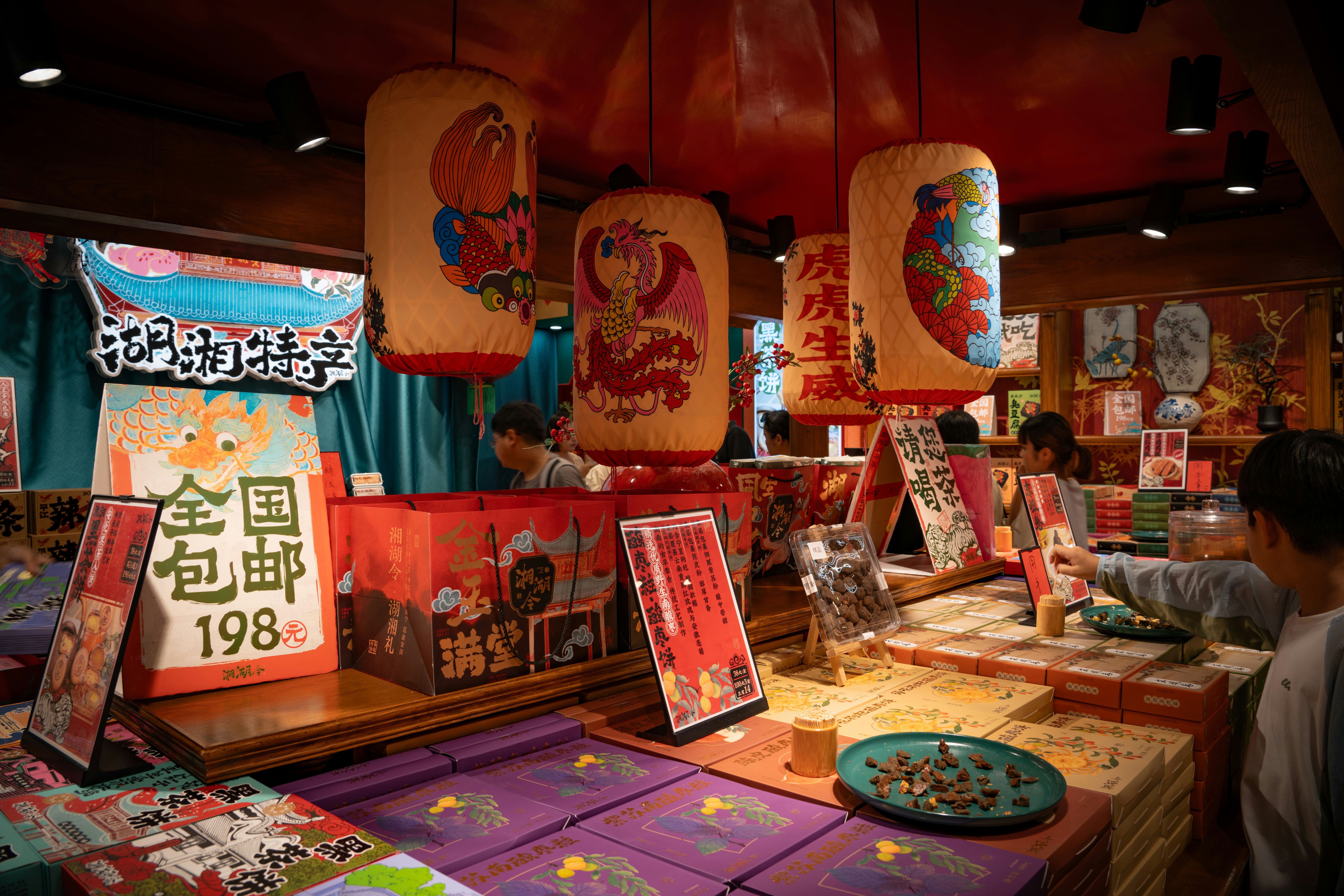 A shop interior with hanging paper lanterns and boxes of food products on display
