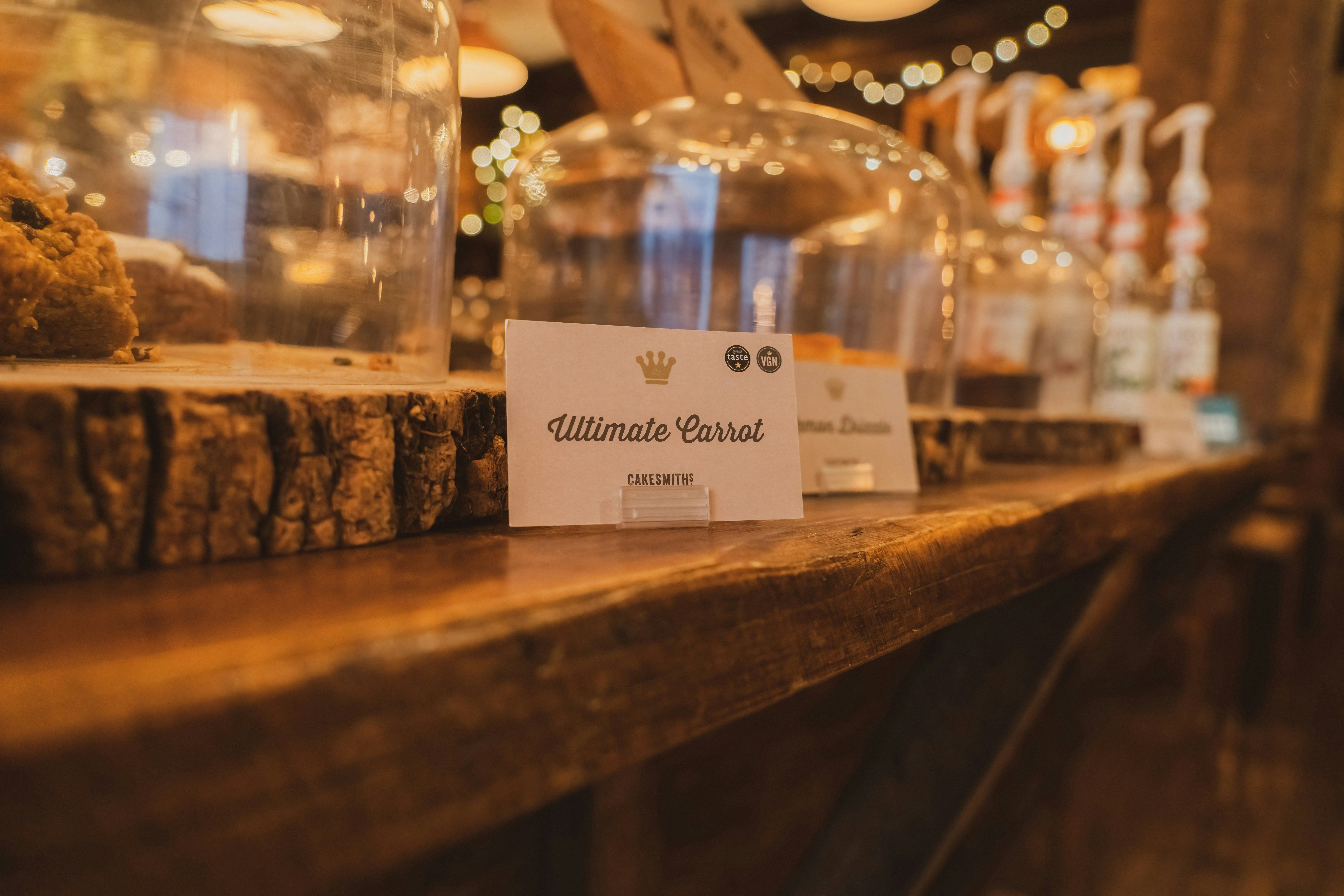 A wooden table topped with glass domes filled with food