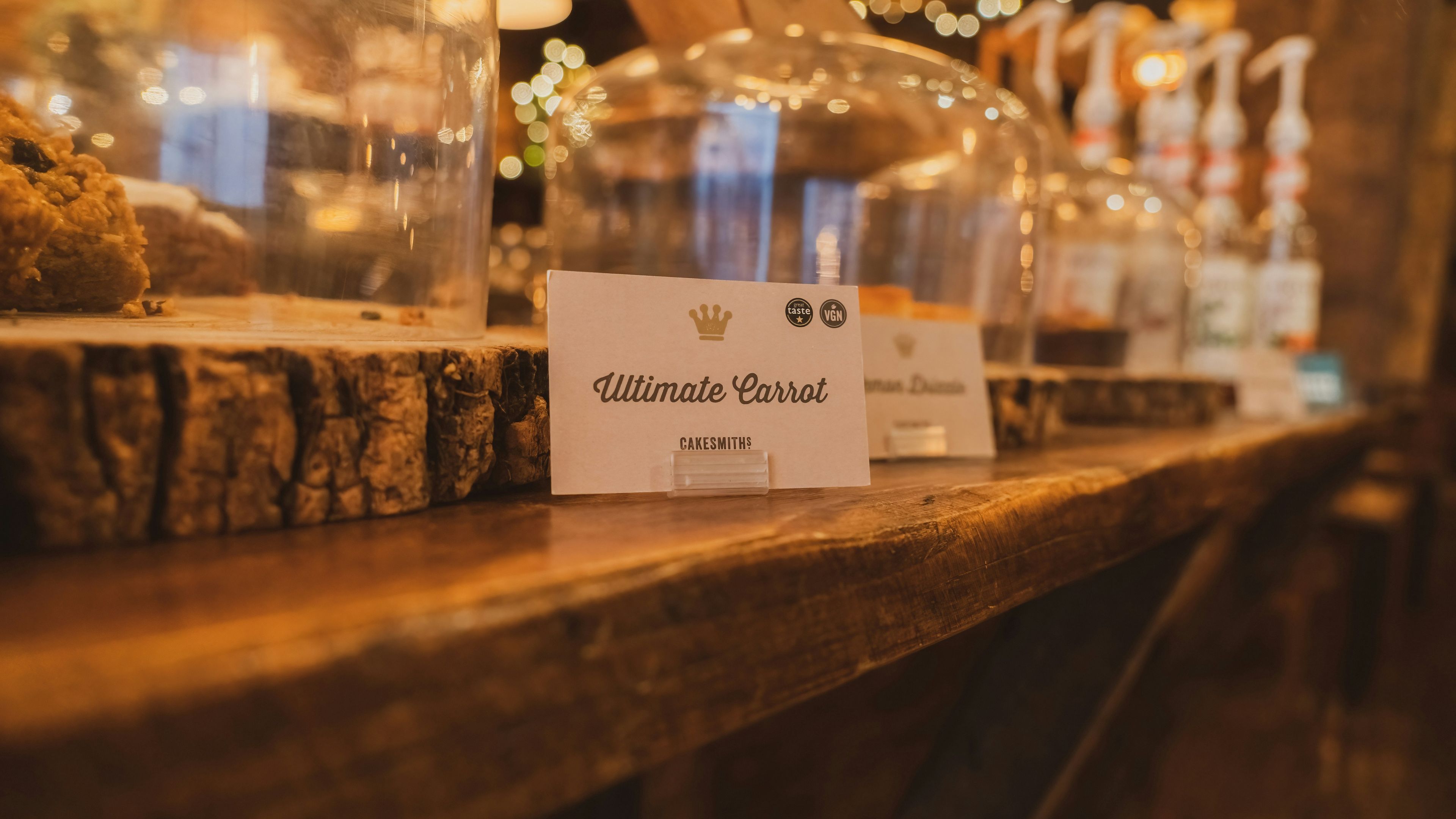 A wooden table topped with glass domes filled with food