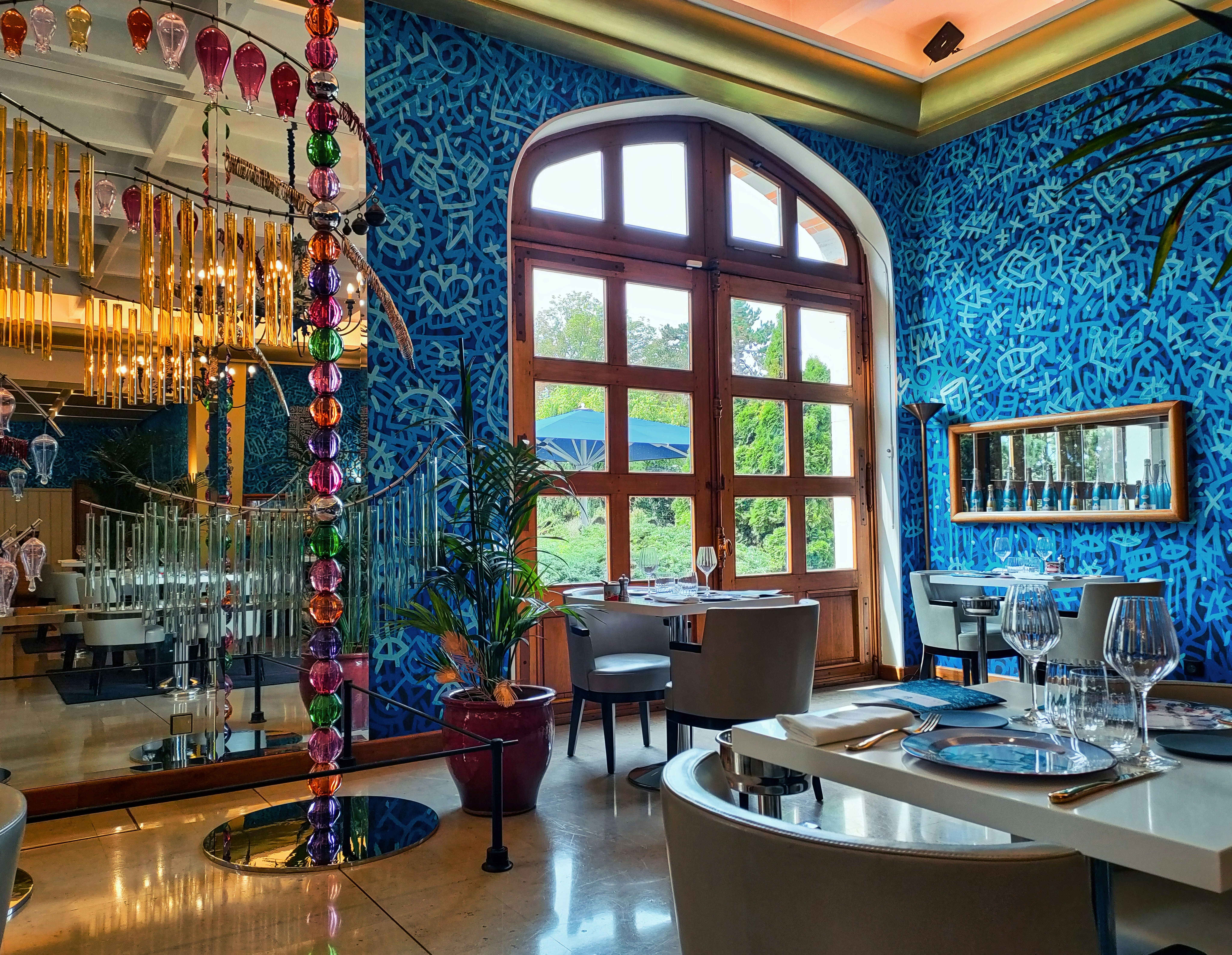 A dining room with blue walls and a chandelier