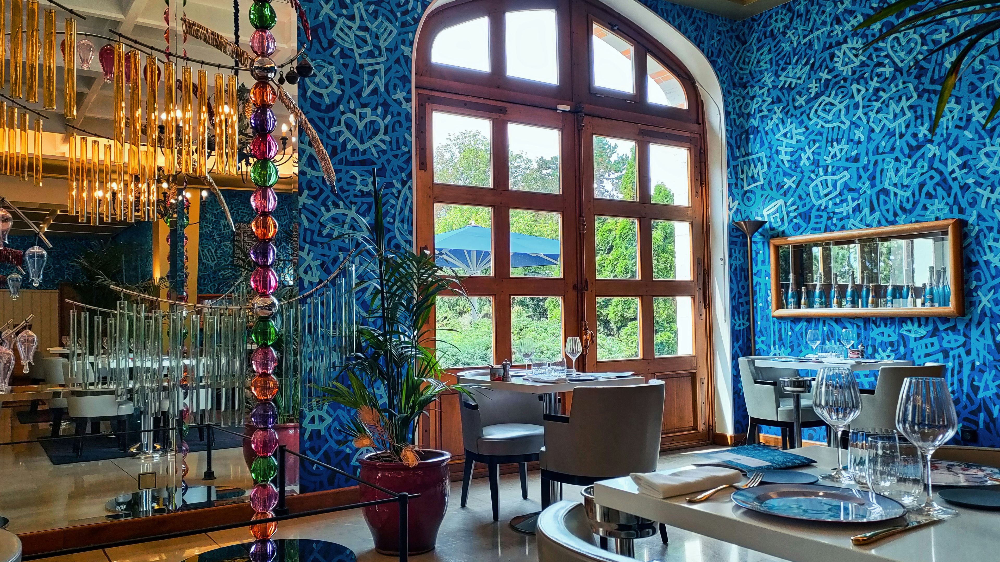 A dining room with blue walls and a chandelier