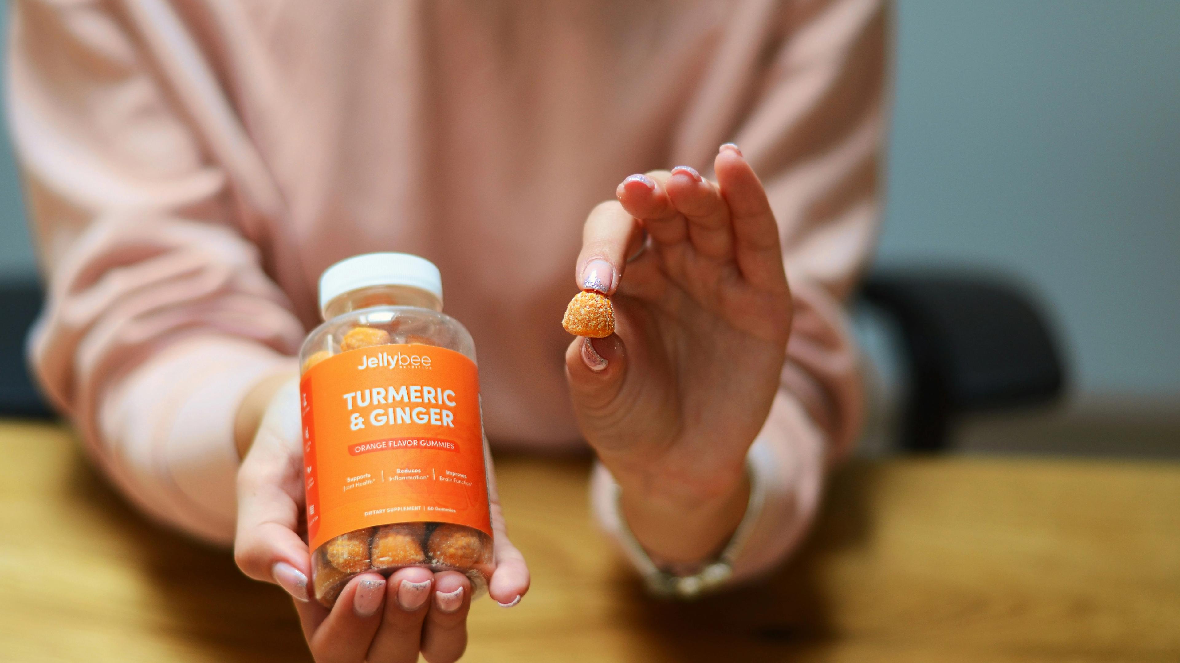Person holding orange plastic bottle