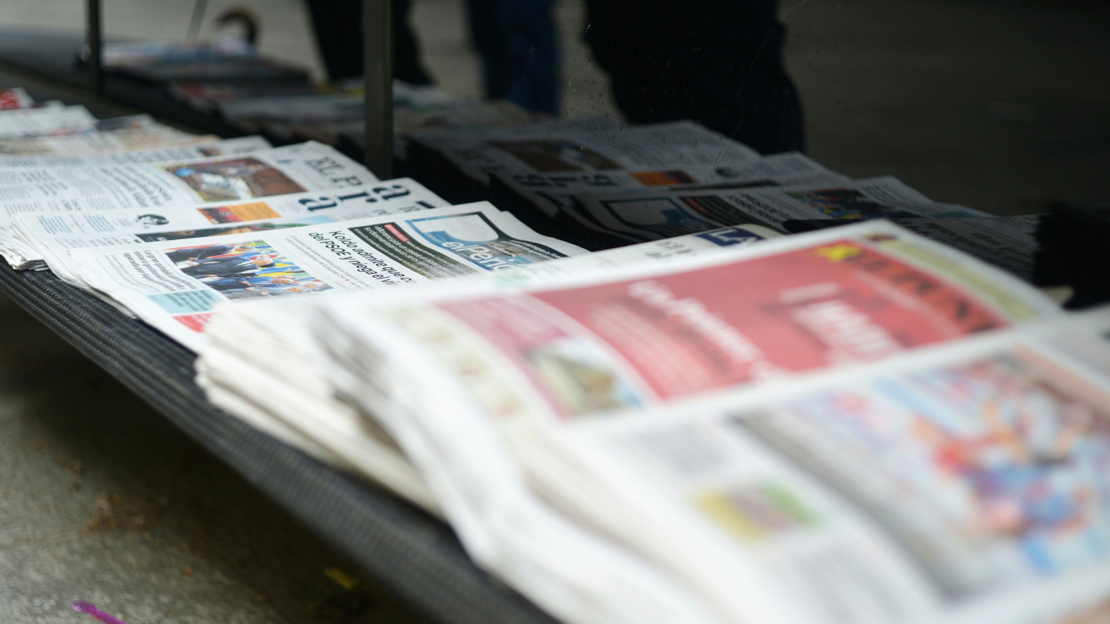 Newspapers neatly stacked on a table
