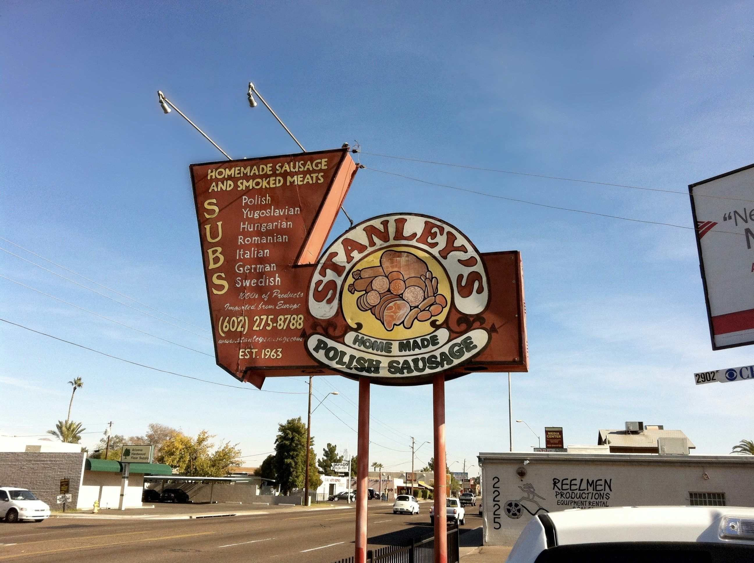 A sign for stanley's irish sausage on the side of the road