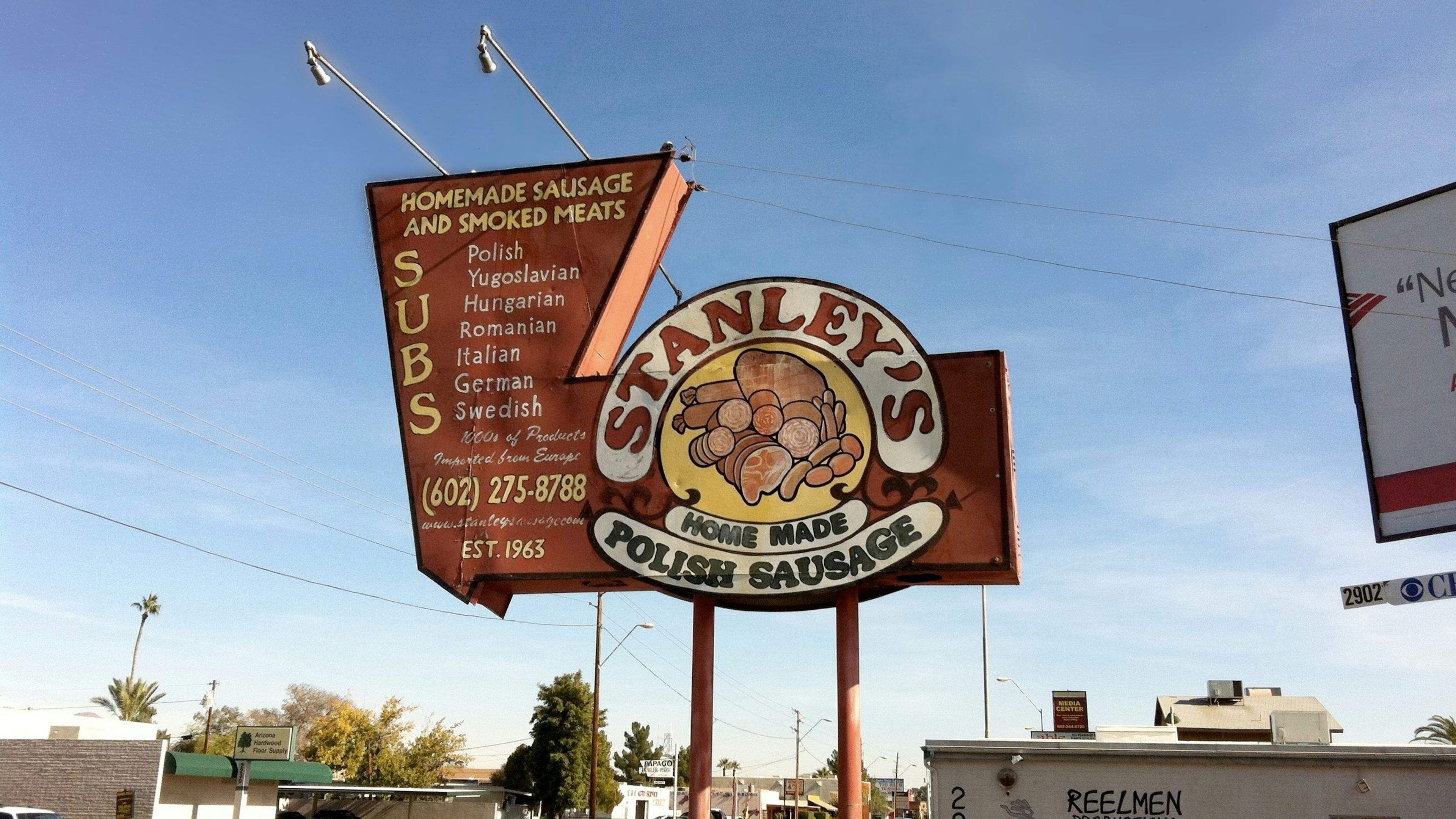 A sign for stanley's irish sausage on the side of the road