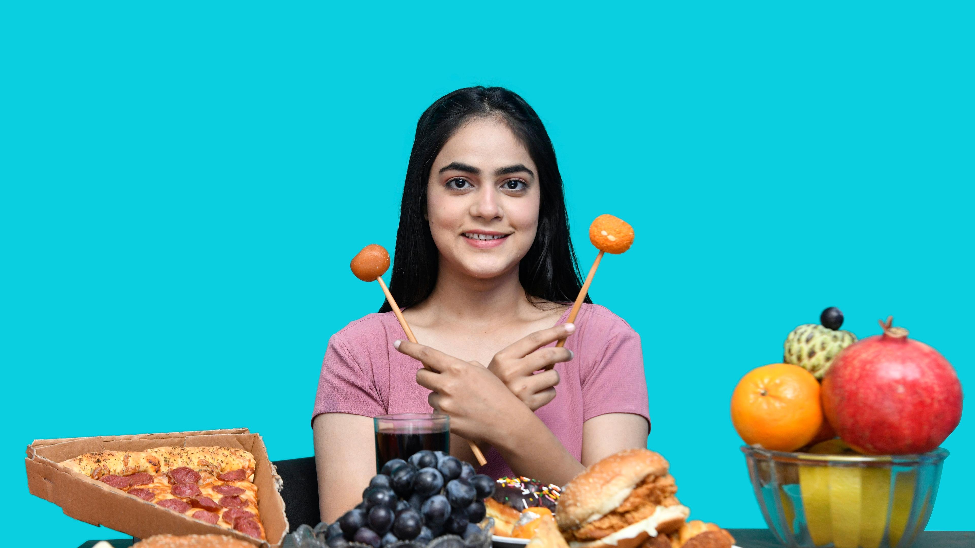 A woman holding a spoon in her mouth with food in front of her