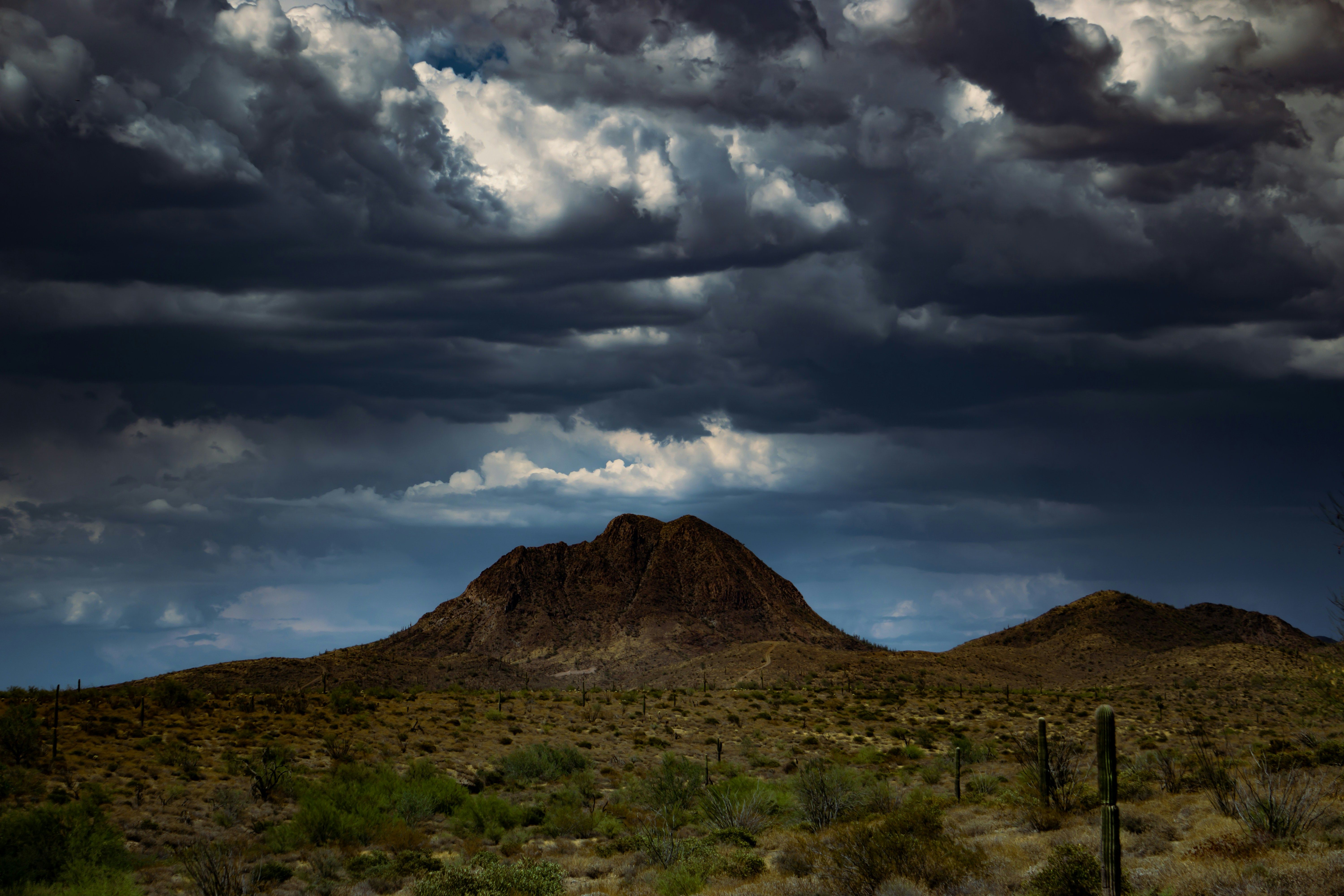 Brown mountain under white clouds during daytime