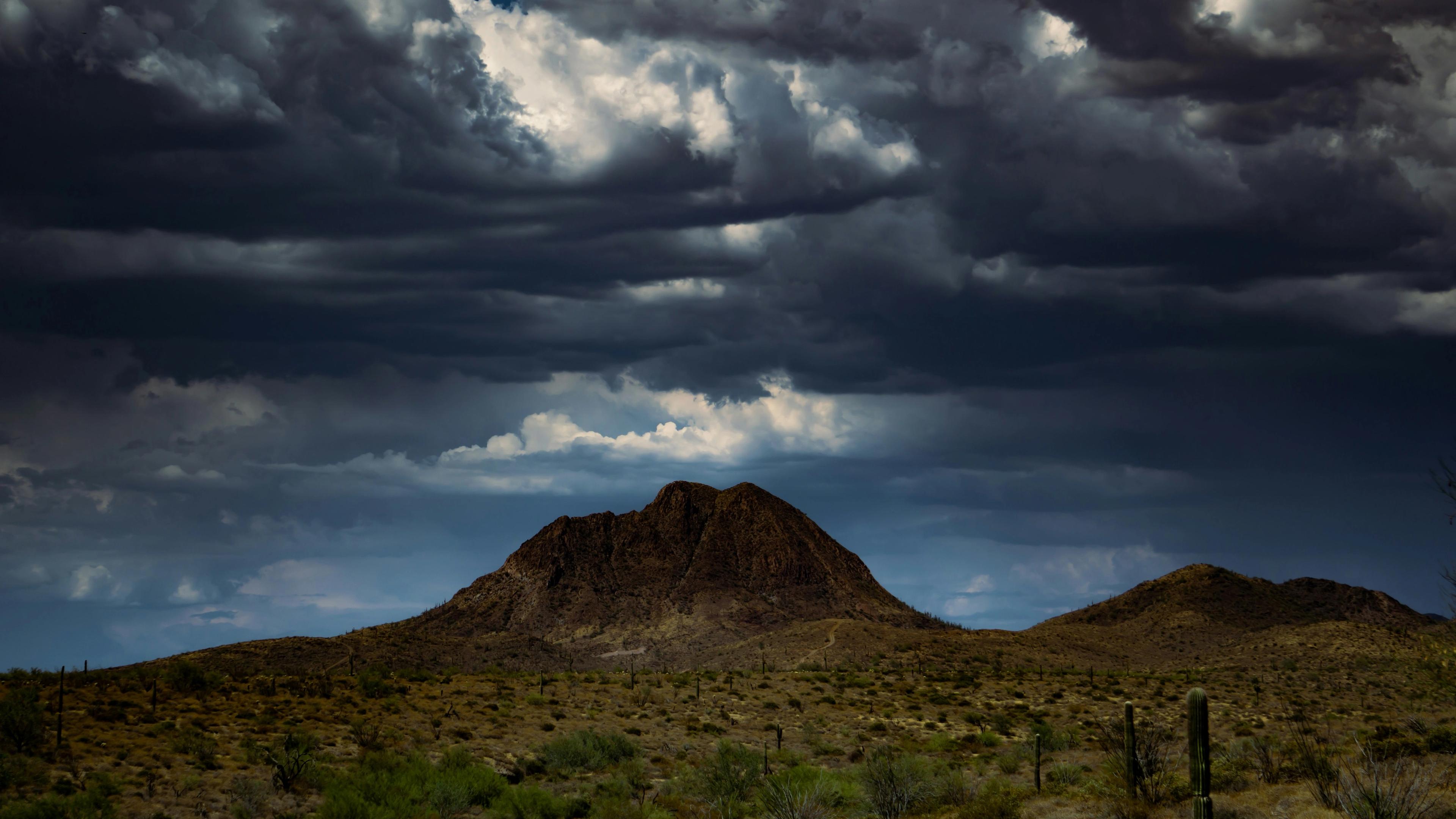 Brown mountain under white clouds during daytime