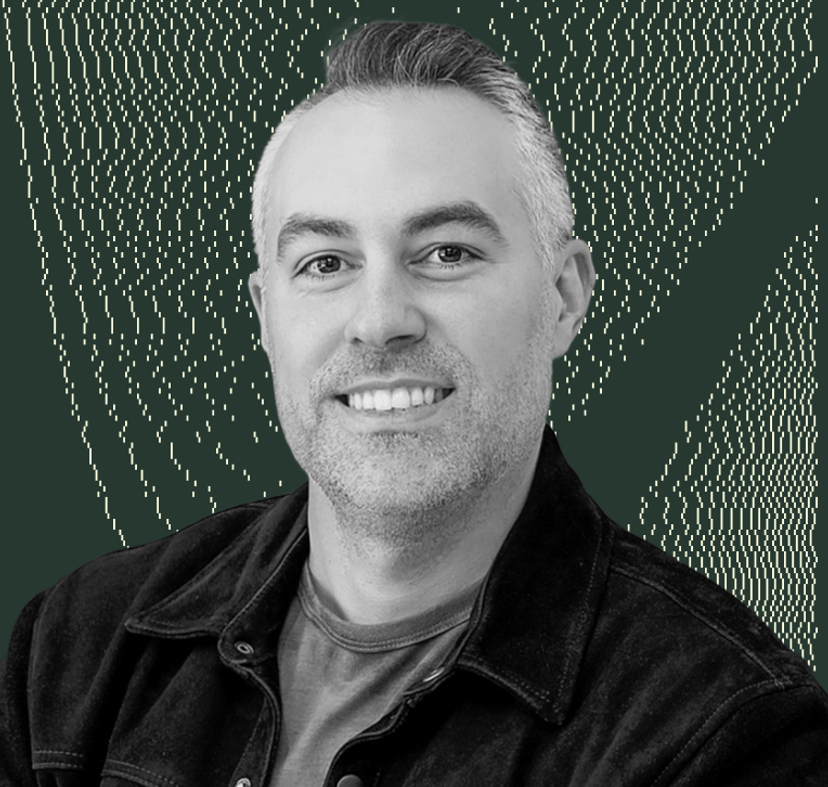 a man in a black jacket is smiling in front of a green background