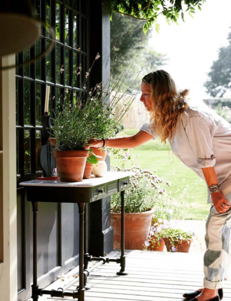 Woman tending to flowers in pots