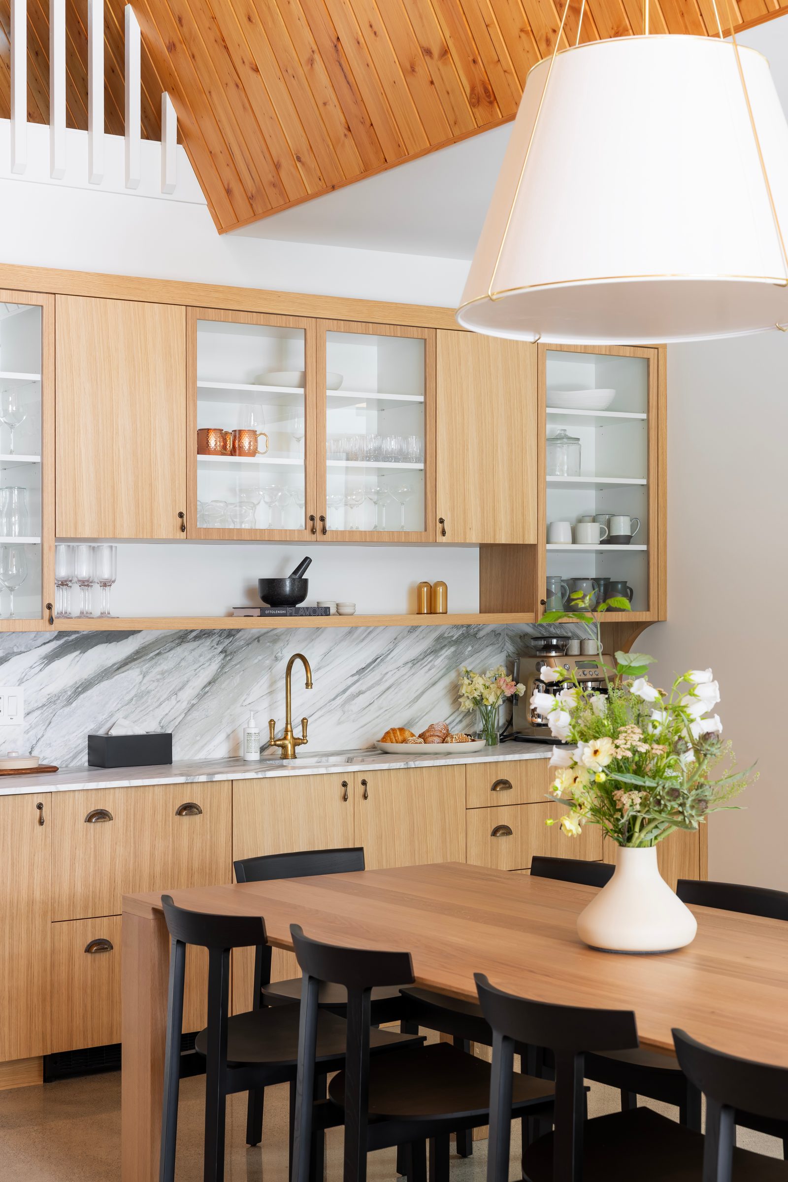 Oak butler's pantry with glazed uppers and a marble backsplash