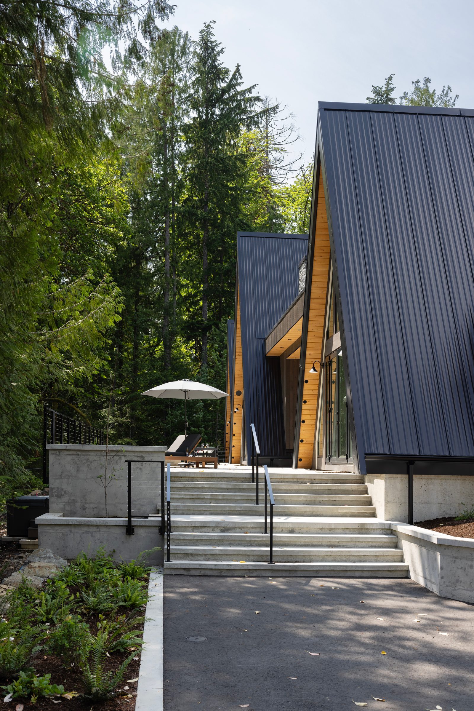 Concrete steps climbing between retaining walls to a black A-frame