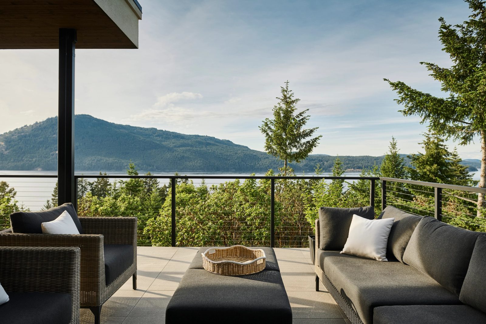 Covered deck with cable rail and wicker seating, Salt Spring Island across the channel