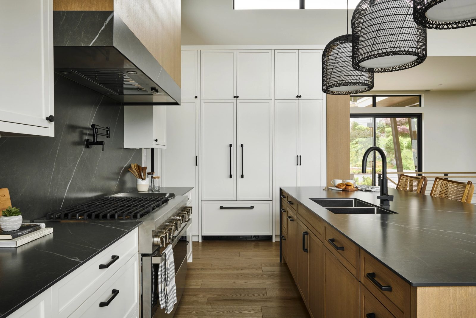 Kitchen range wall in soapstone, panelled refrigeration, oak island with undermount sink