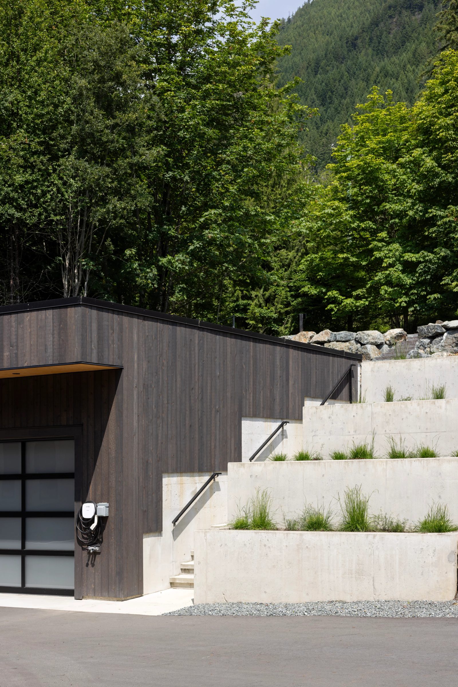 Flat-roofed garage beside stepped board-formed concrete planters