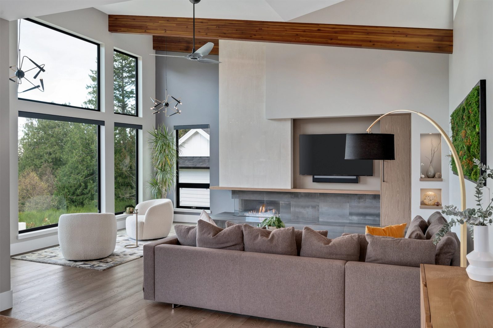 Living room with a plaster fireplace surround, blackened steel hearth tile and a preserved moss panel on the far wall