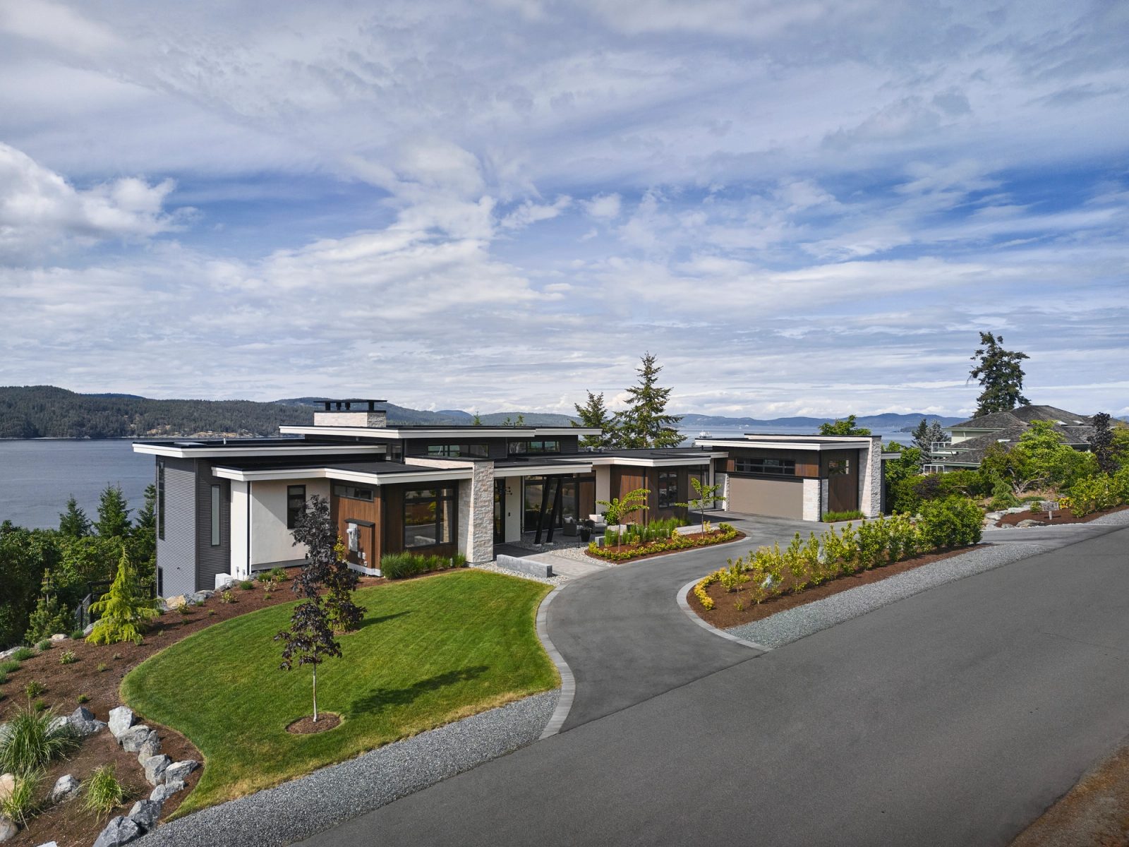 Single-storey street elevation above Satellite Channel, curved driveway, Salt Spring Island beyond