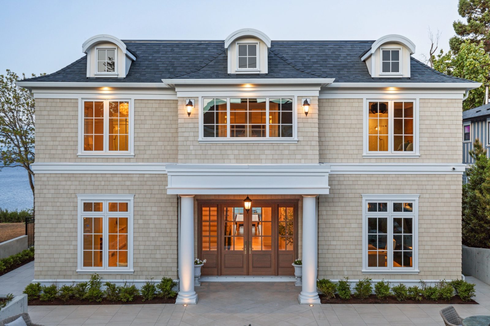 Courtyard elevation at dusk, symmetrical, doors glazed through to the water