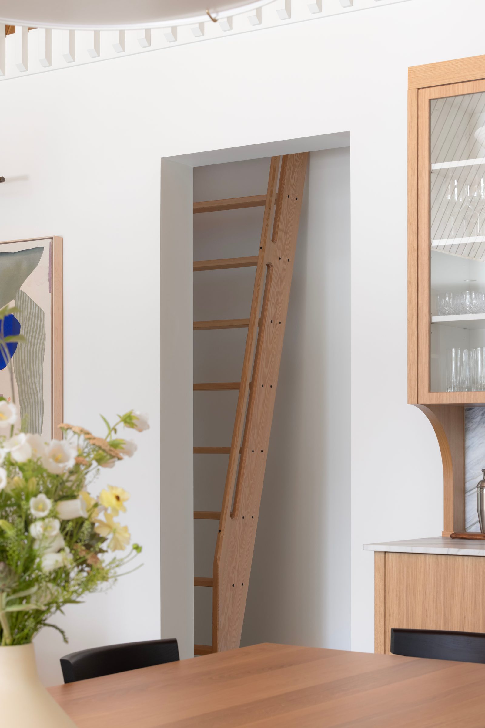 Fir ladder set into a wall recess beside oak cabinetry