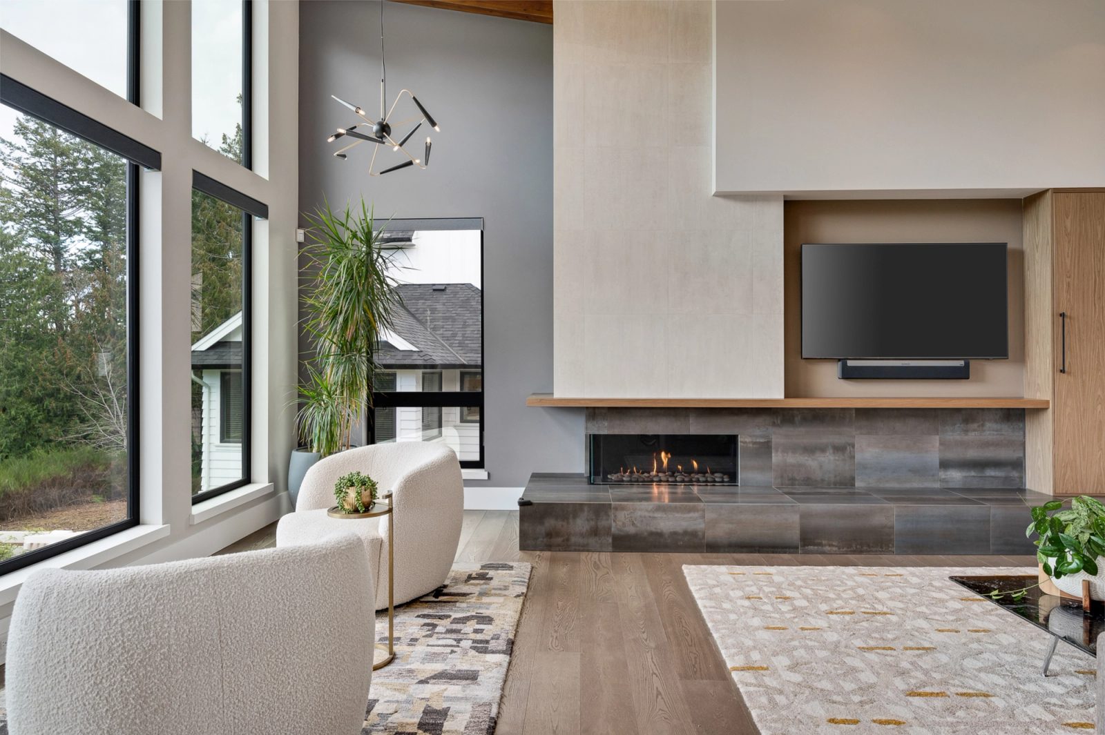 Gas fireplace set in blackened steel tile beneath a plaster chimney breast, with a white oak shelf running the wall