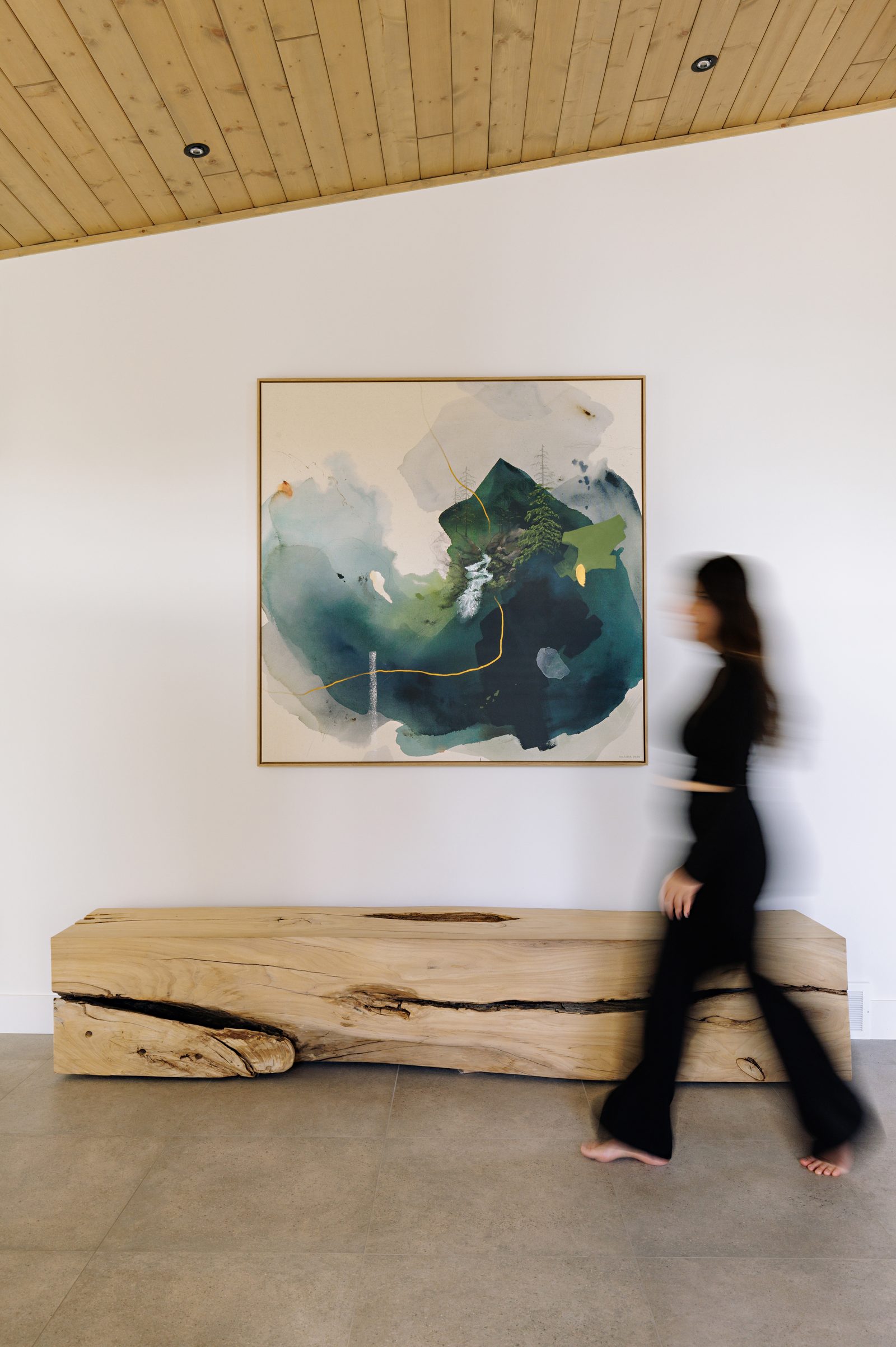 the same wall with a figure passing in front of it, motion-blurred against the pale stone floor.