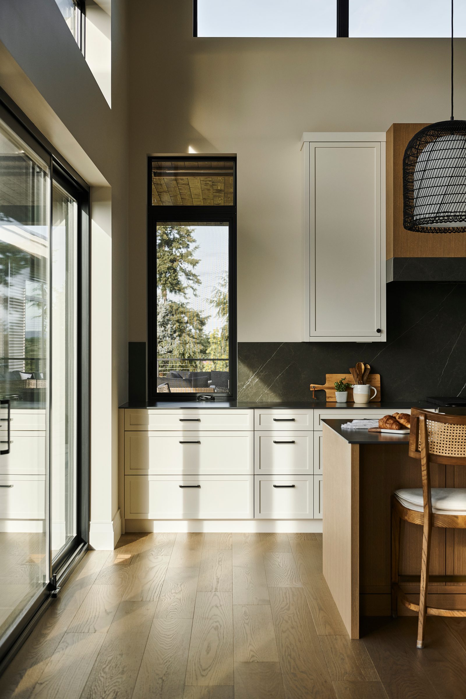 Window slot beside the range wall, oak island end and white cabinetry in morning light
