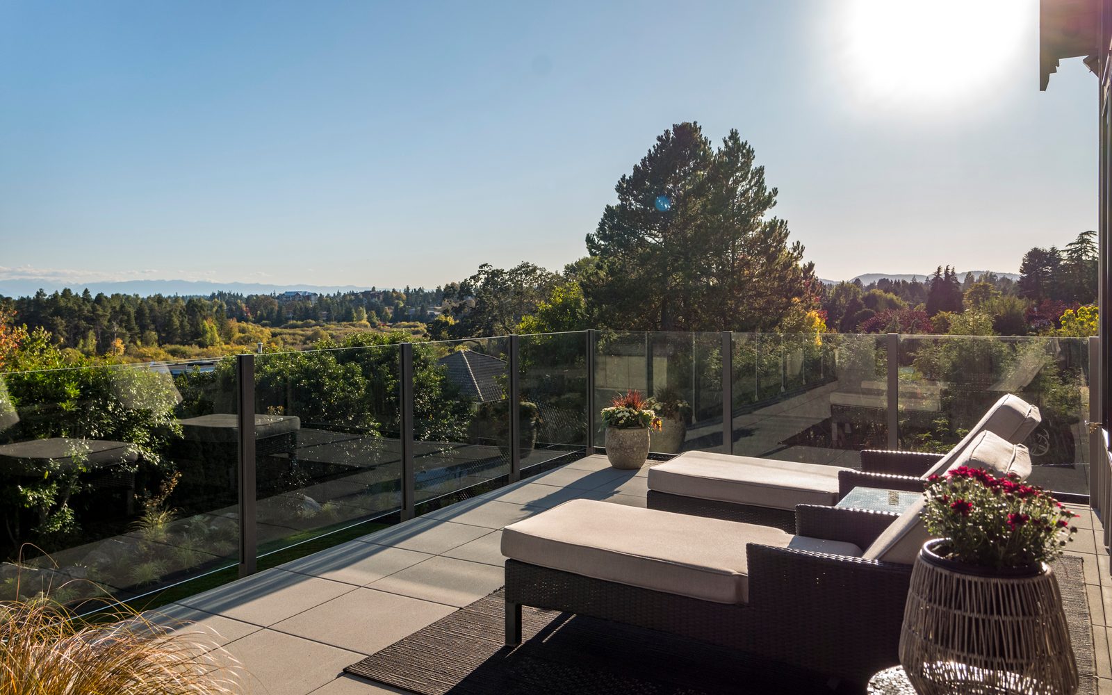 Deck loungers behind a glass rail with the valley and mountains beyond