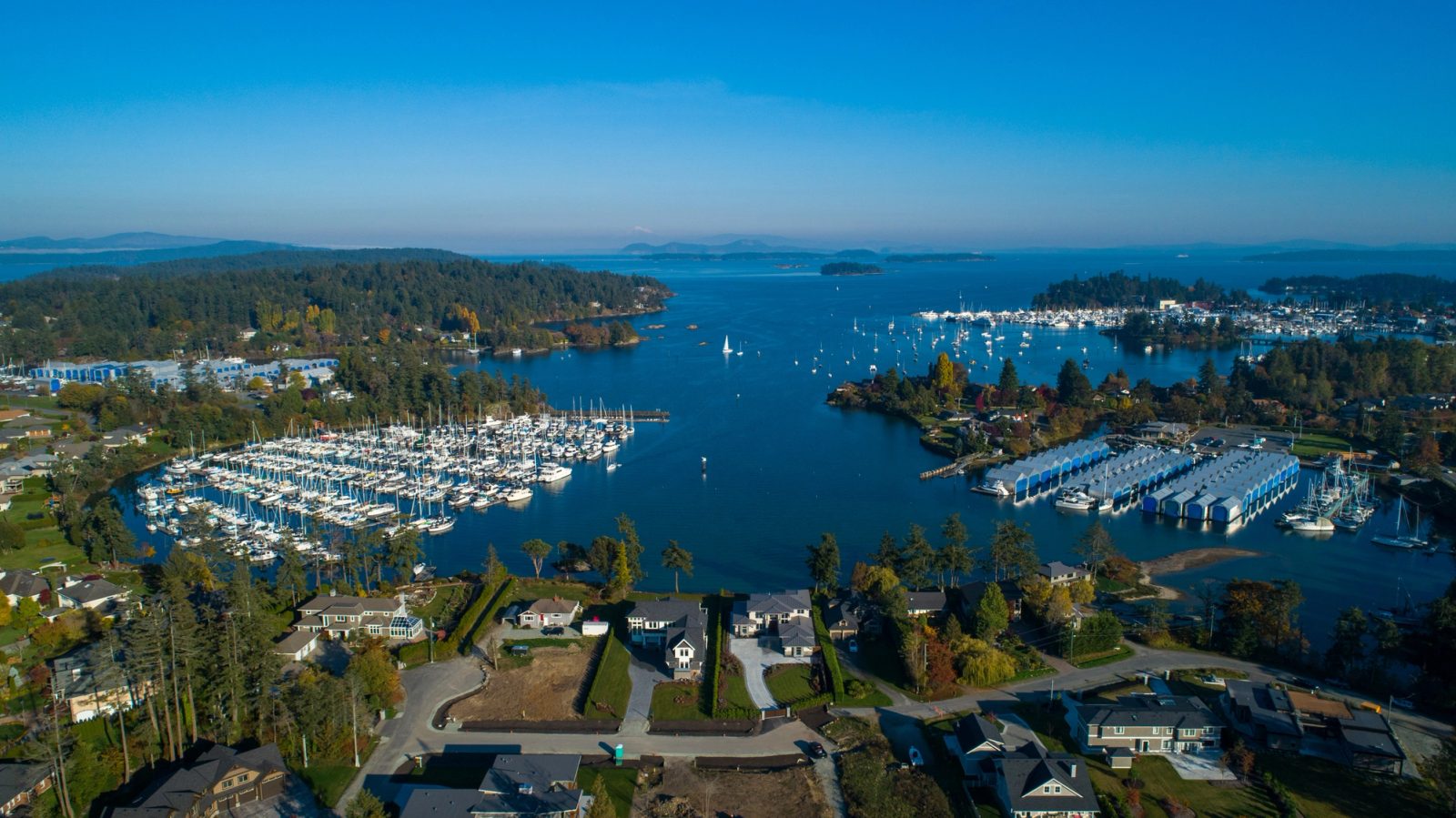 Aerial view over Tsehum Harbour with marinas, moored sailboats and the Gulf Islands beyond