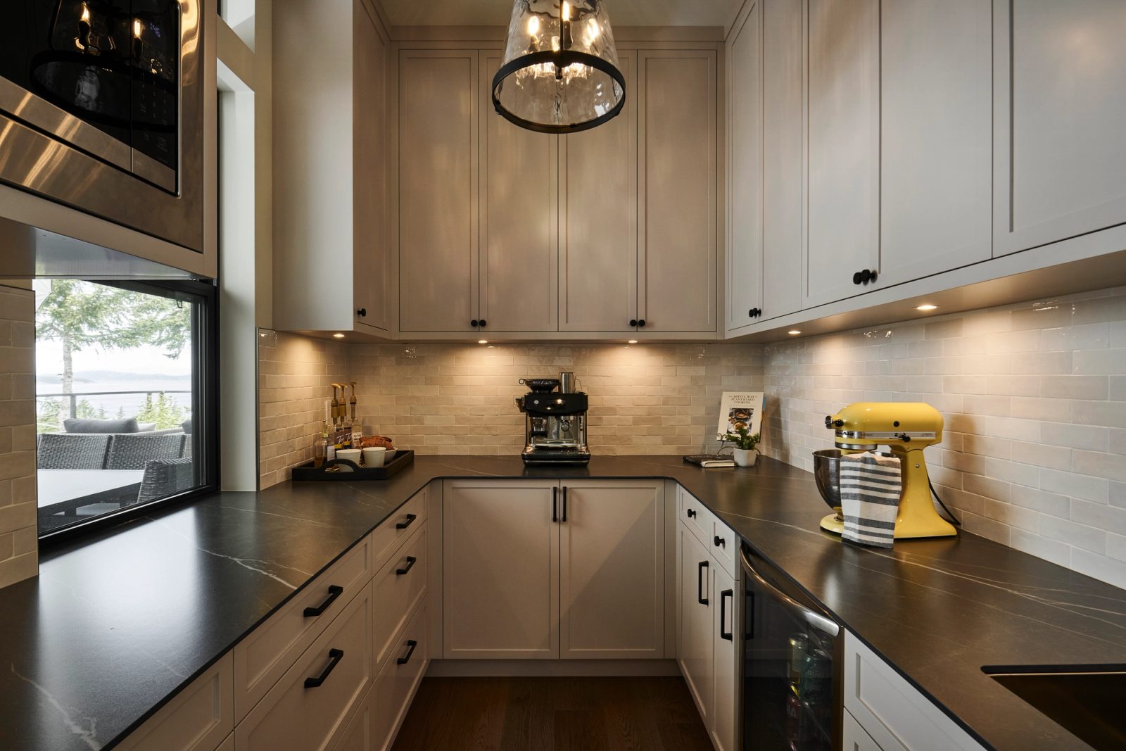 Butler pantry in warm grey, tile backsplash, coffee station beneath upper cabinets