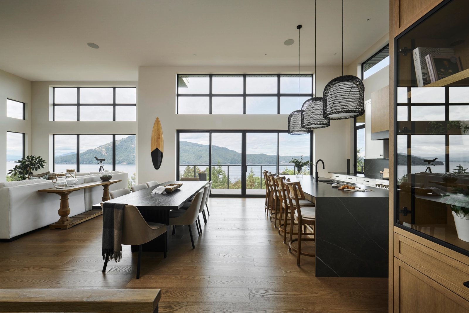 Living, dining and kitchen in one volume, north-facing glass across Satellite Channel