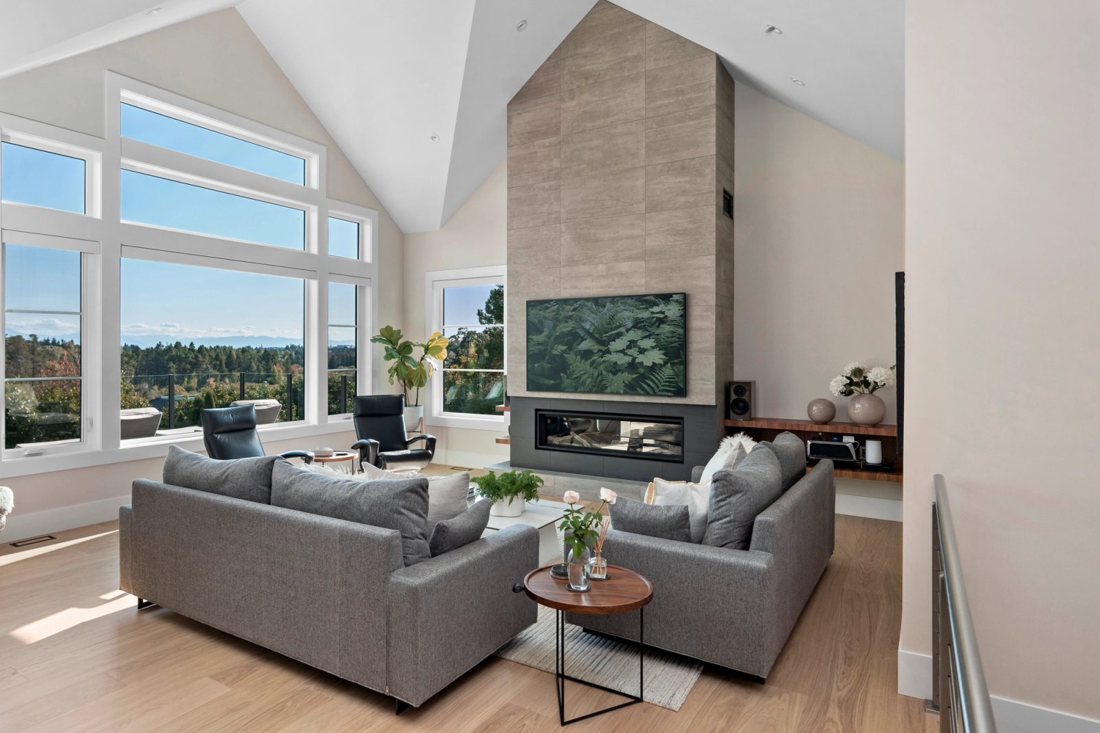 Vaulted living room with a full-height tiled fireplace and window walls facing the valley