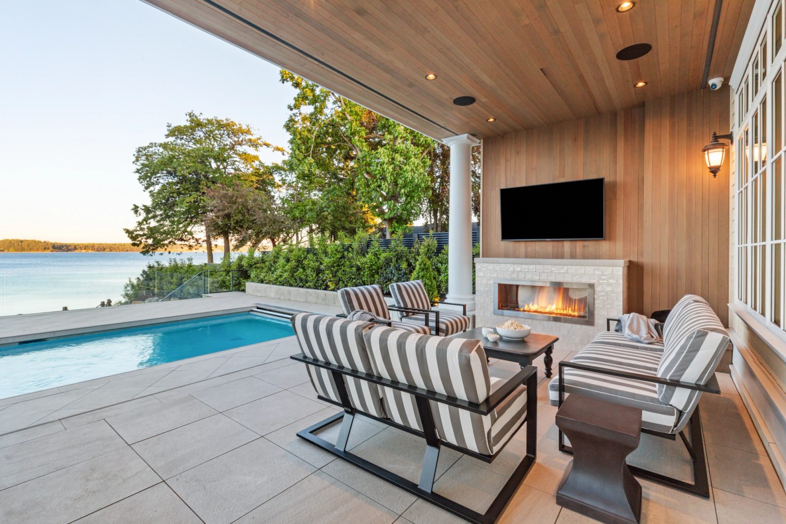Covered loggia, cedar ceiling, outdoor fireplace, pool beyond