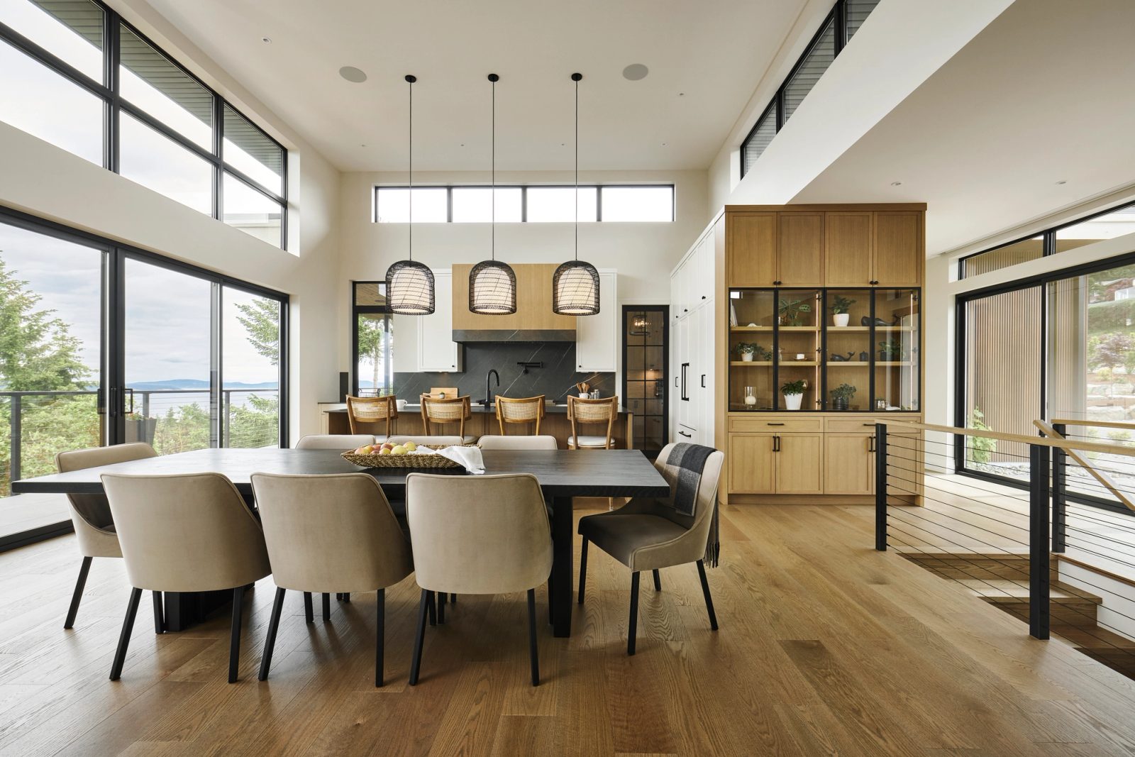 Dining table and kitchen island under clerestory glazing, oak display cabinet right