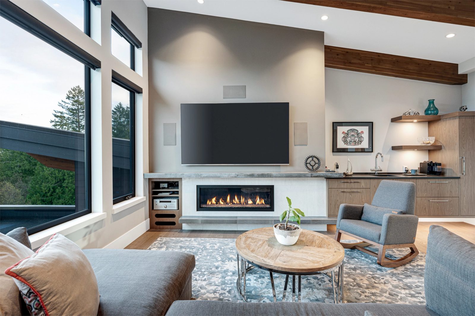 Upper family room with a linear gas fireplace, wet bar and a cedar beam ceiling