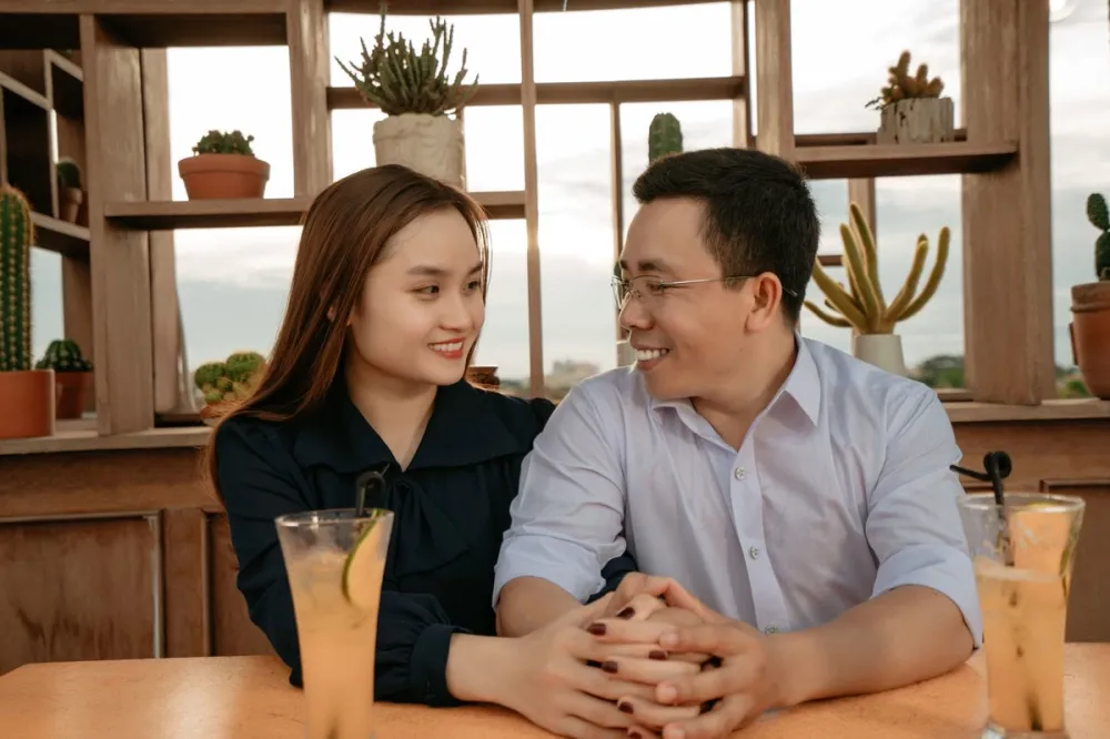 나무 선반이 있는 카페 테이블에서 마주 보고 웃는 남녀